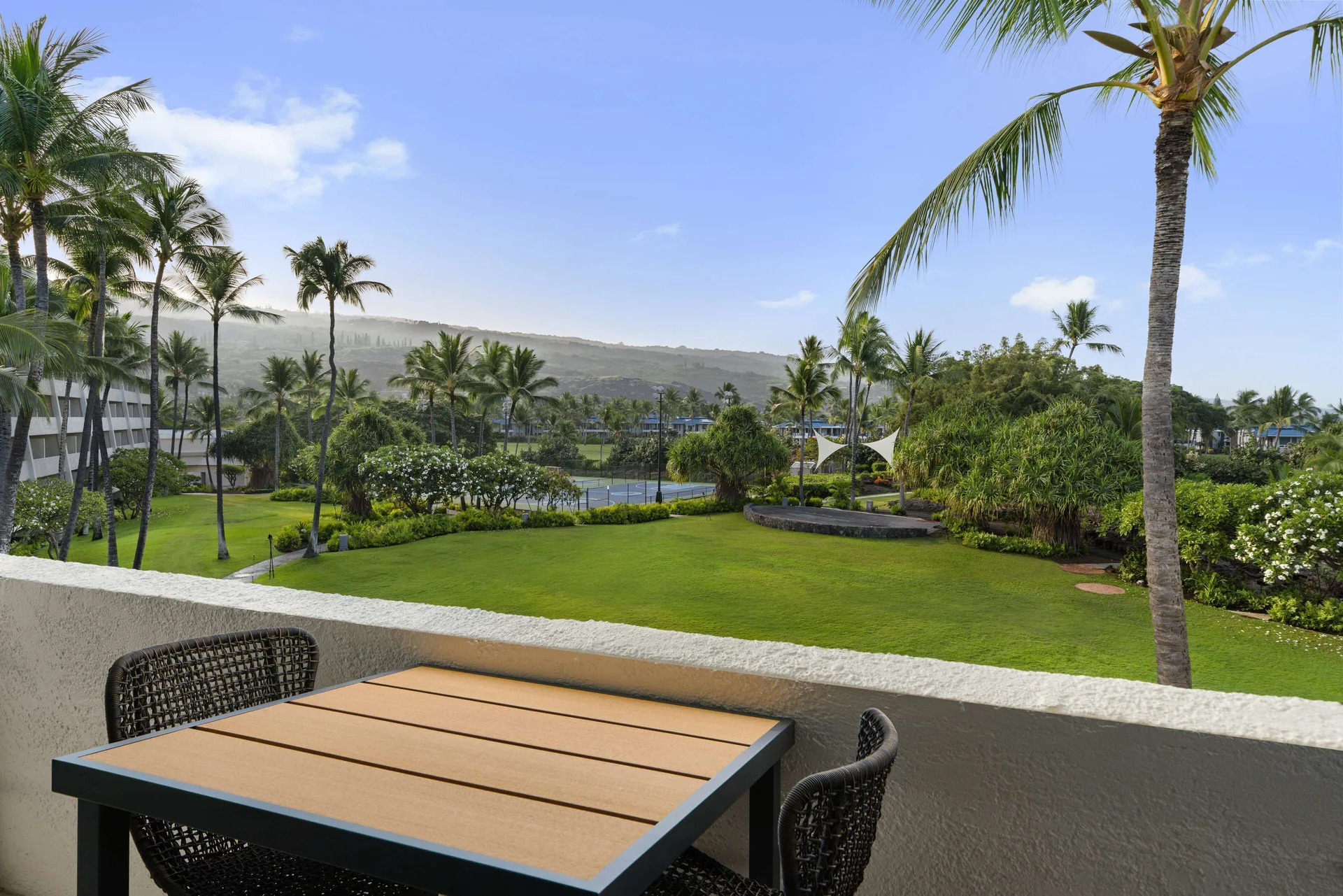 Balcony table overlooking lawns and palms from a room at Outrigger Kona Resort and Spa.