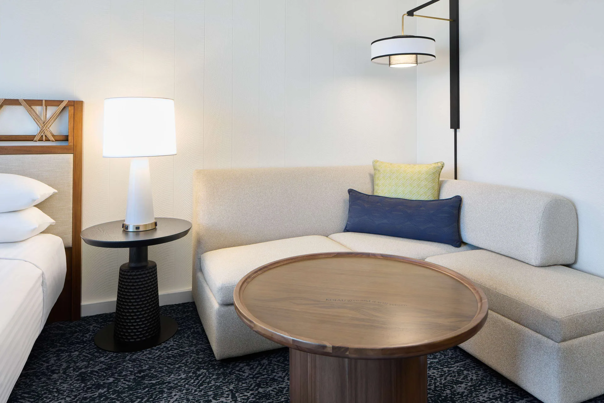 Sofa seating area beside a bed in a resort view room at Outrigger Kona Resort and Spa.