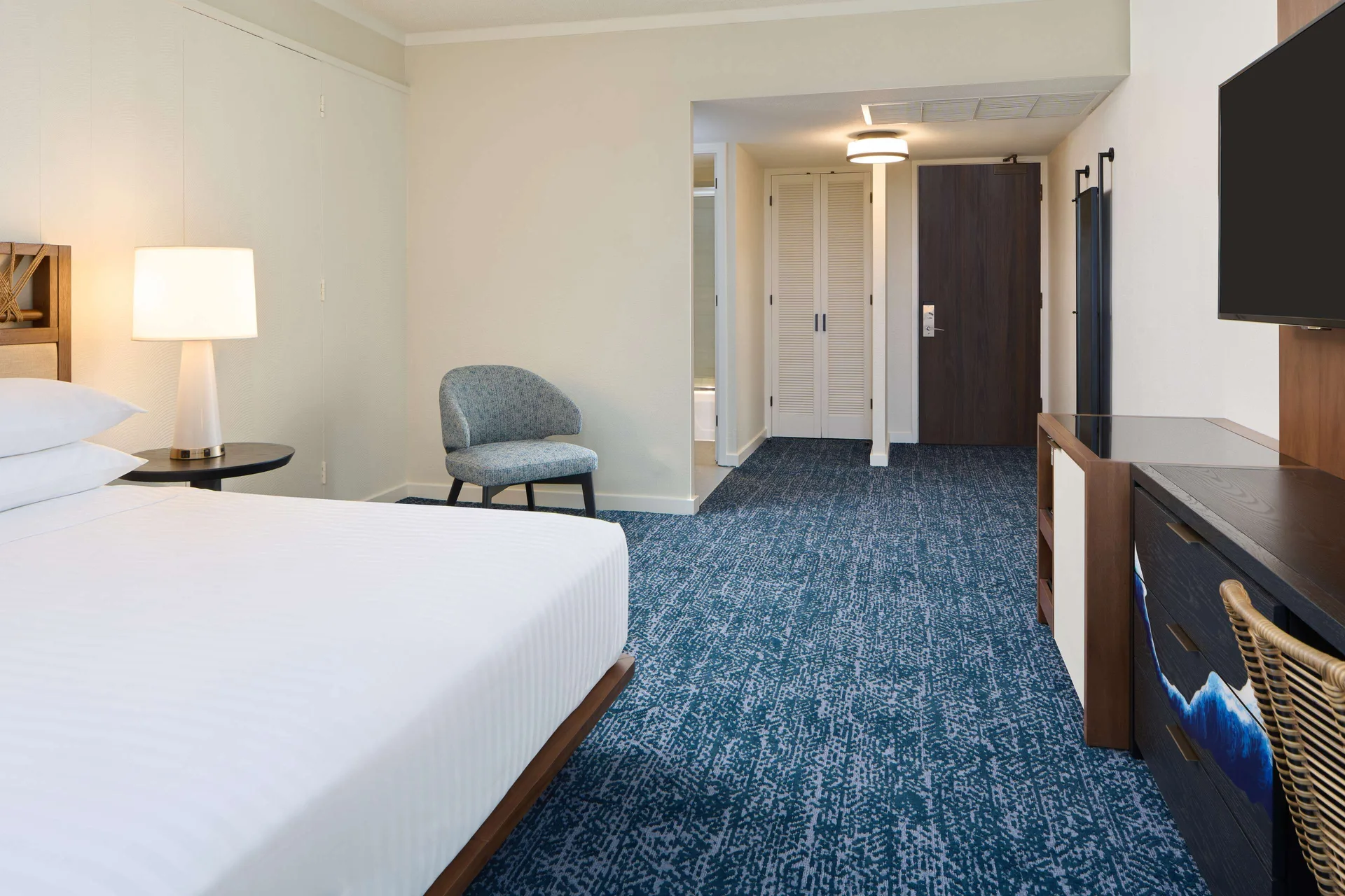 Resort view room with bed, chair, TV, and entry area at Outrigger Kona Resort and Spa.