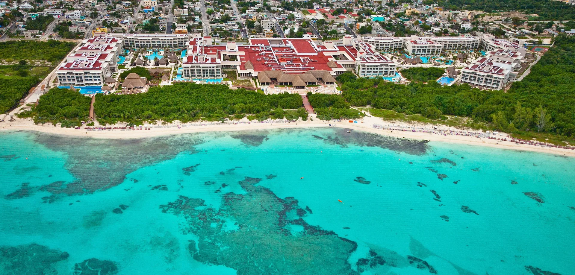 Aerial view of the beachfront resort and turquoise sea at Paradisus La Perla Riviera Maya.