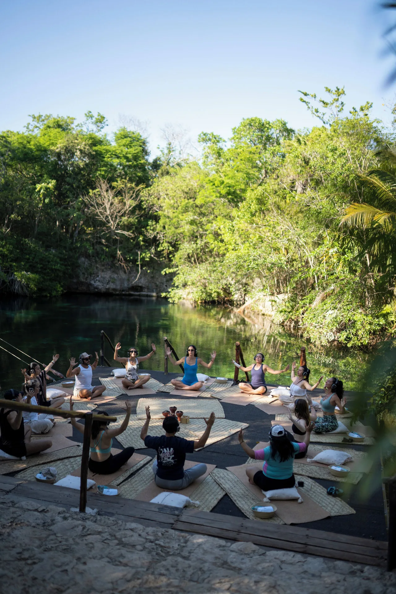 Group yoga session beside a cenote-like lagoon at Paradisus La Perla Riviera Maya.