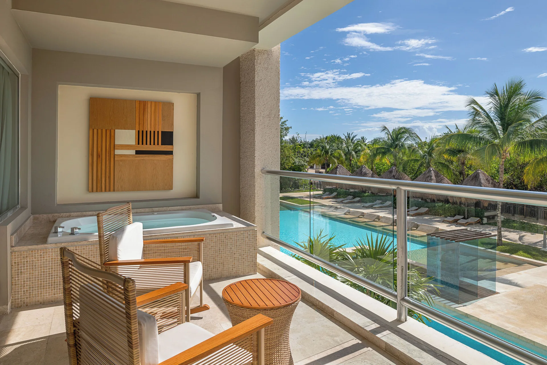 Suite Nature View balcony with whirlpool tub and poolside palms at Paradisus La Perla Riviera Maya.