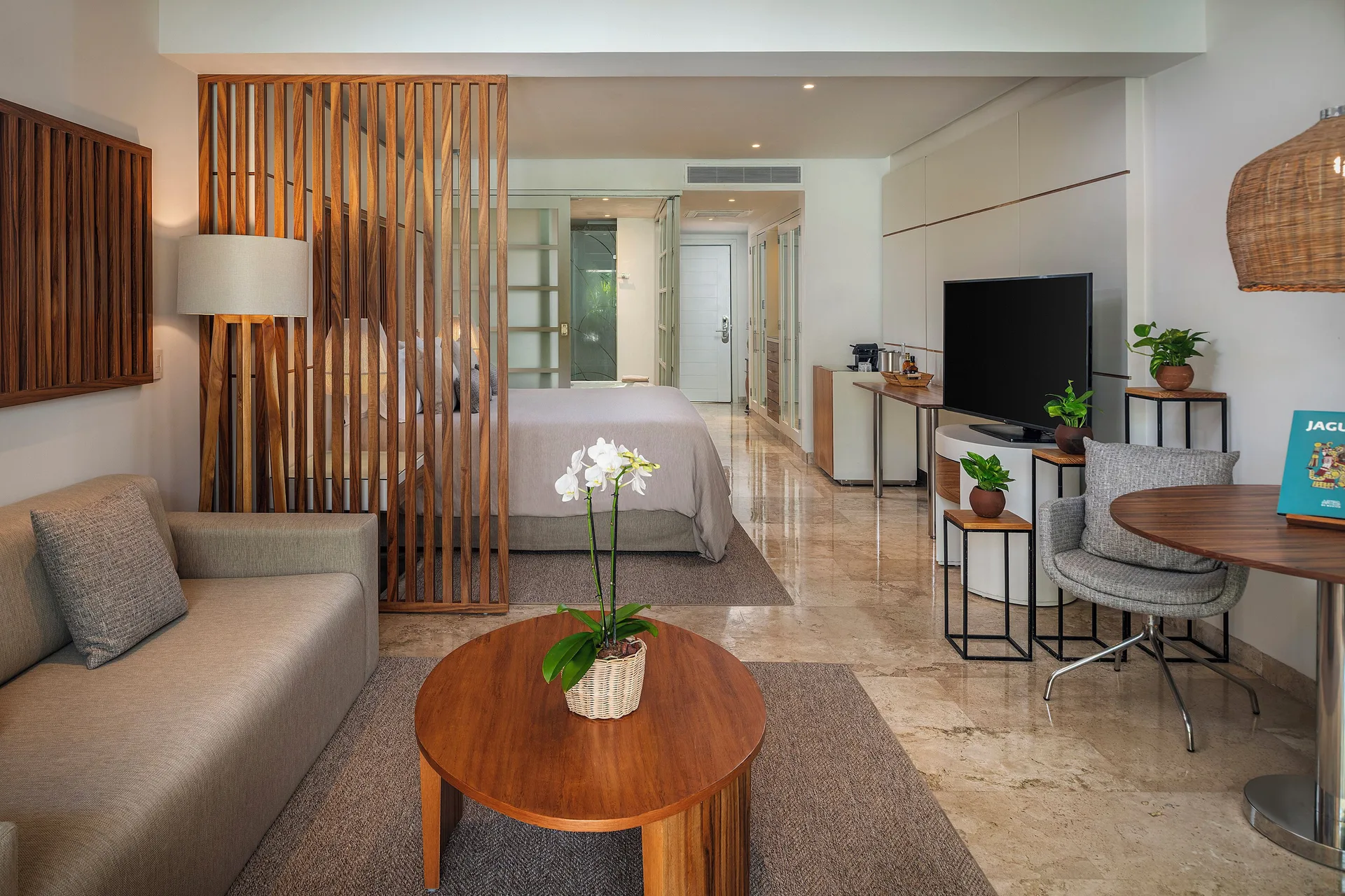 The Reserve Junior Suite Nature View living area and bed at Paradisus La Perla Riviera Maya.