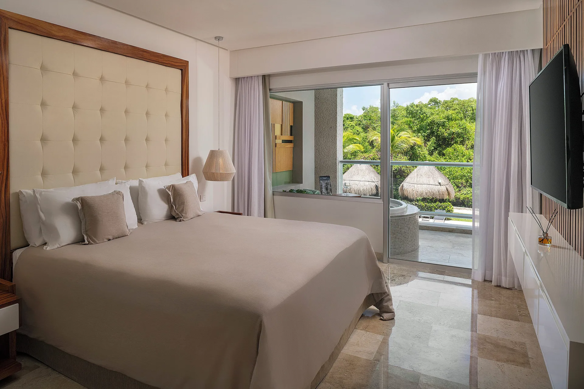 King bed and balcony in The Reserve Master Suite Nature View at Paradisus La Perla Riviera Maya.