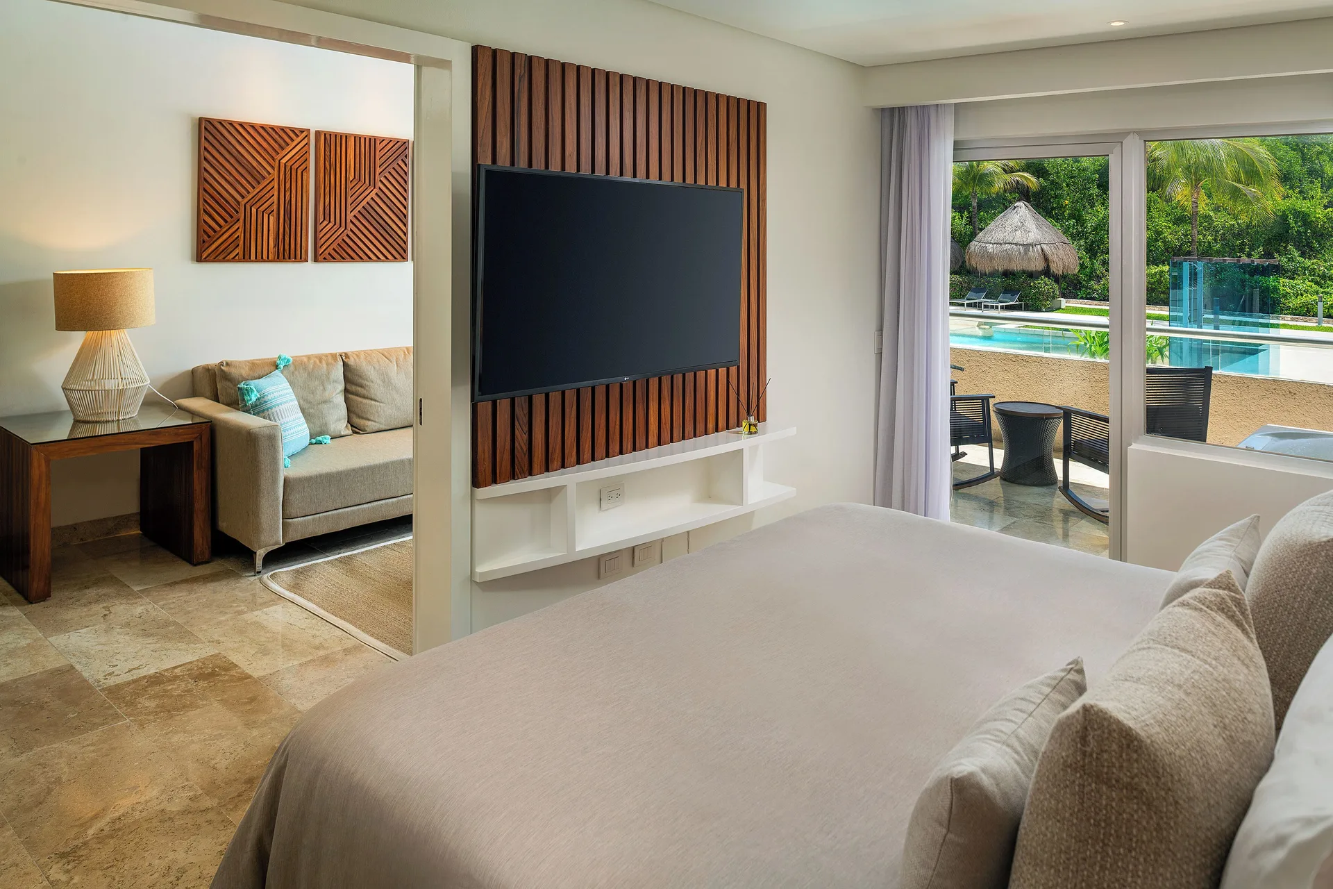 Reserve Suite Swim Up bedroom with bed, lounge area, and pool view at Paradisus La Perla Riviera Maya.