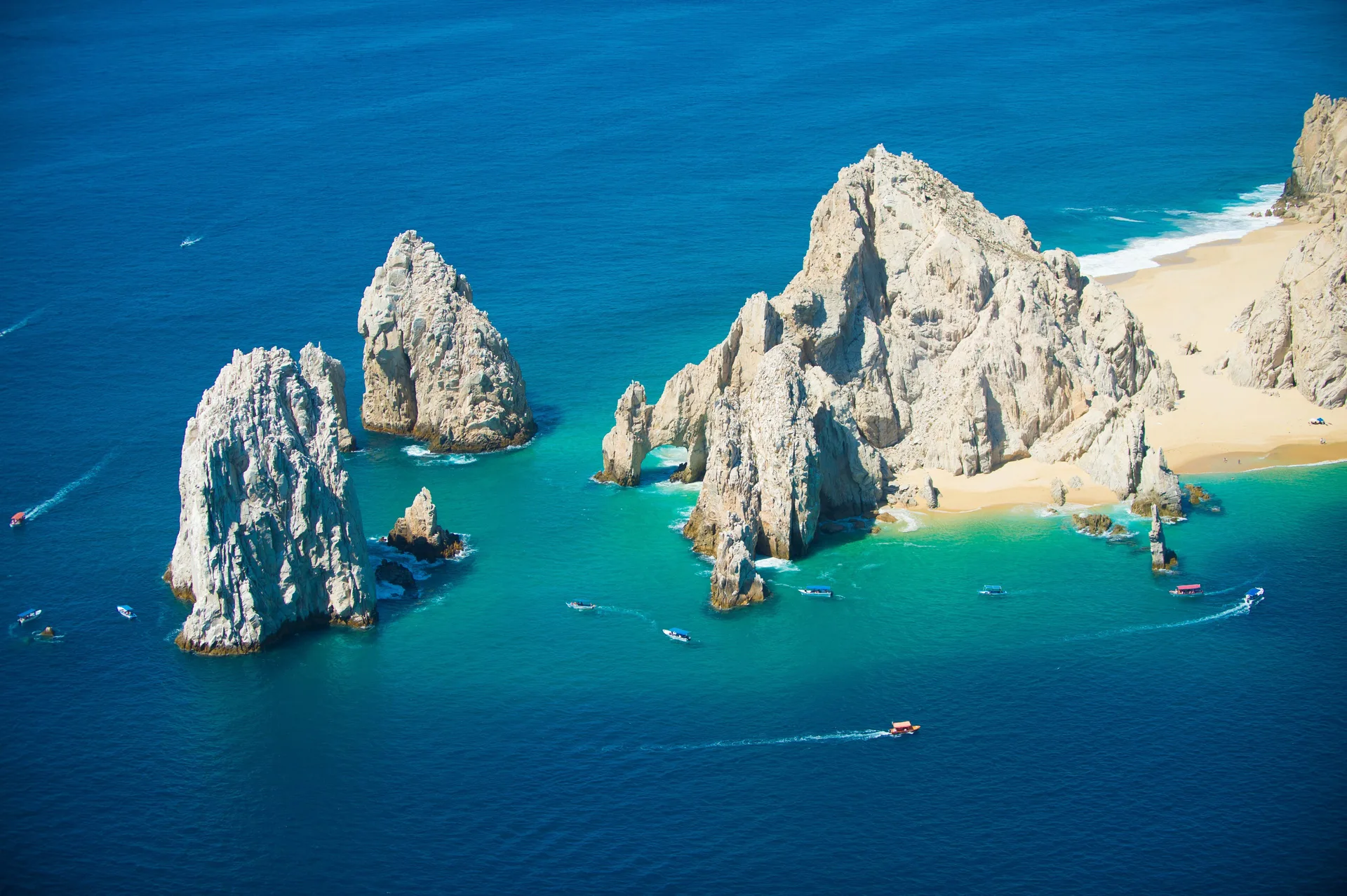 Aerial view of Land's End rock formations and blue water near Playa Grande Resort & Grand Spa.