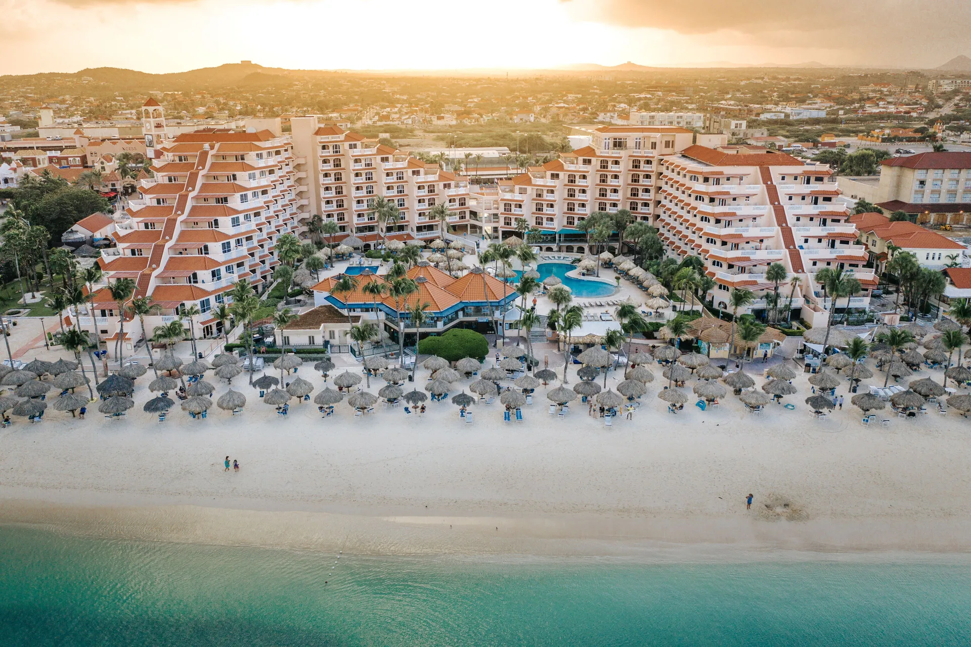 Aerial beachfront view of Playa Linda Beach Resort, pools, palapas, sand and turquoise water.