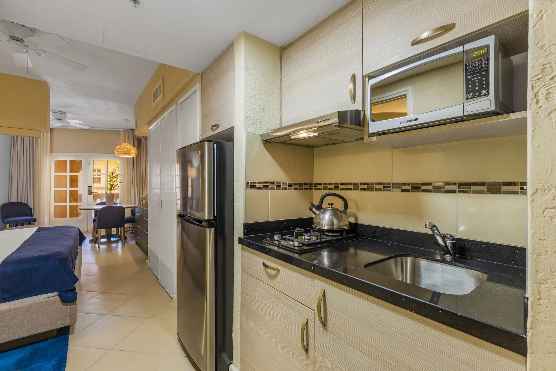 Guest room kitchenette with refrigerator, cooktop, microwave and sink at Playa Linda Beach Resort.