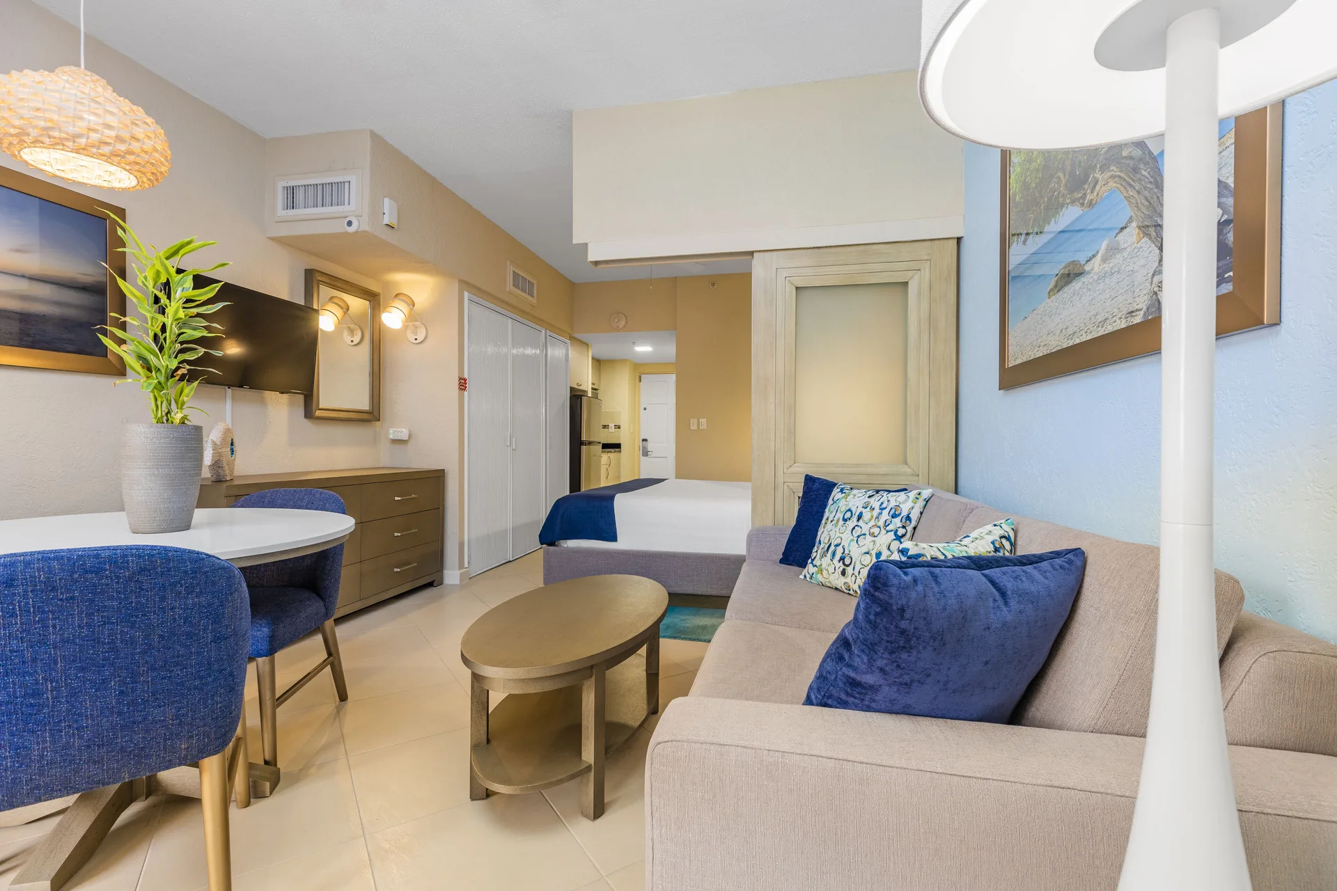 Guest room sitting area with sofa, table, dining nook and bed at Playa Linda Beach Resort.