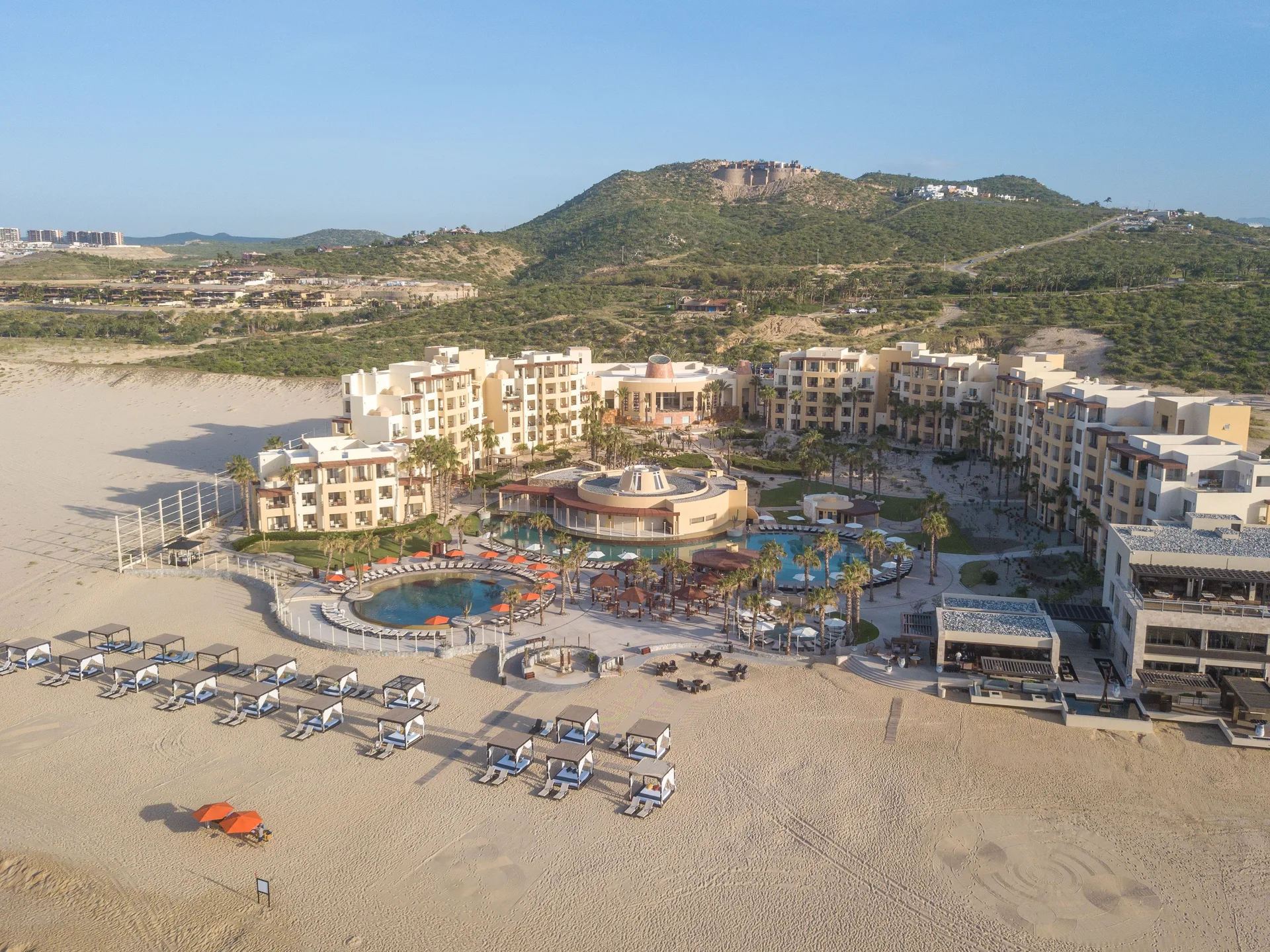 Aerial view of beachfront resort buildings and pools at Pueblo Bonito Pacifica Golf & Spa Resort.