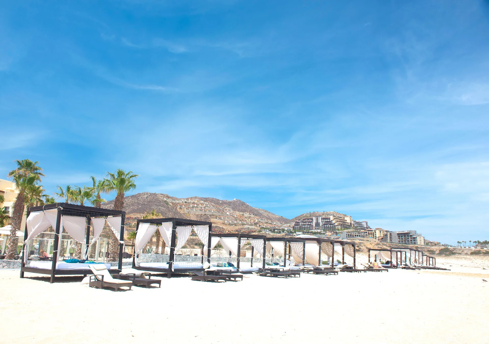 Beach cabanas and loungers on the sand at Pueblo Bonito Pacifica Golf & Spa Resort.