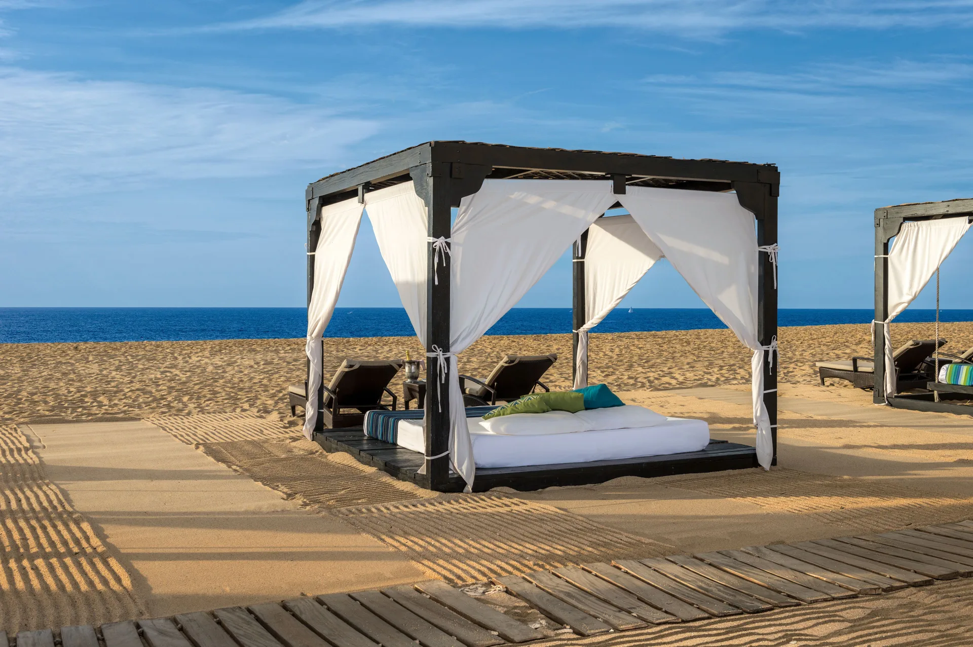 Beach cabanas with white curtains at Pueblo Bonito Pacifica Golf & Spa Resort.