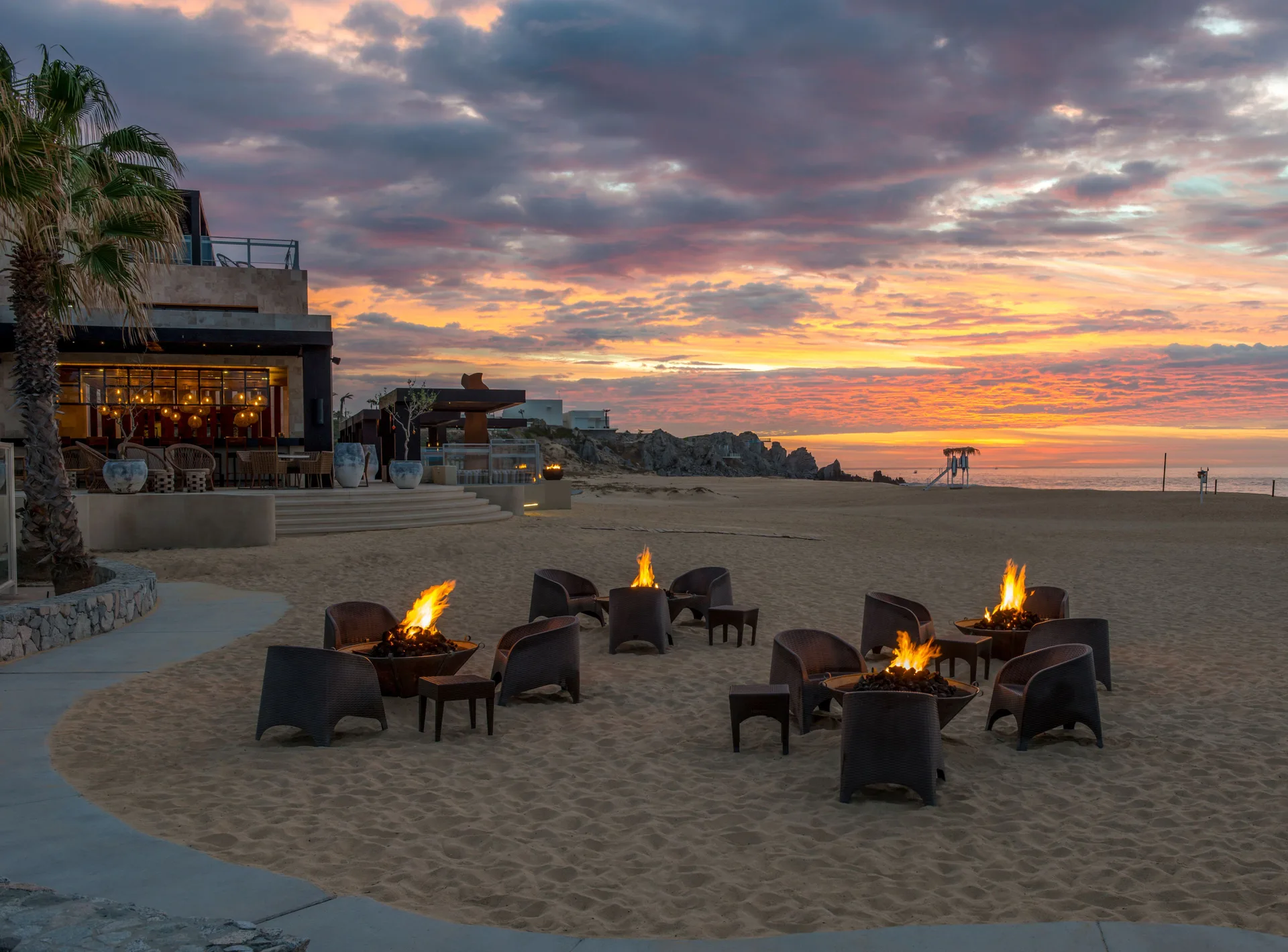 Beach fire pits and lounge seating at sunset at Pueblo Bonito Pacifica Golf & Spa Resort.