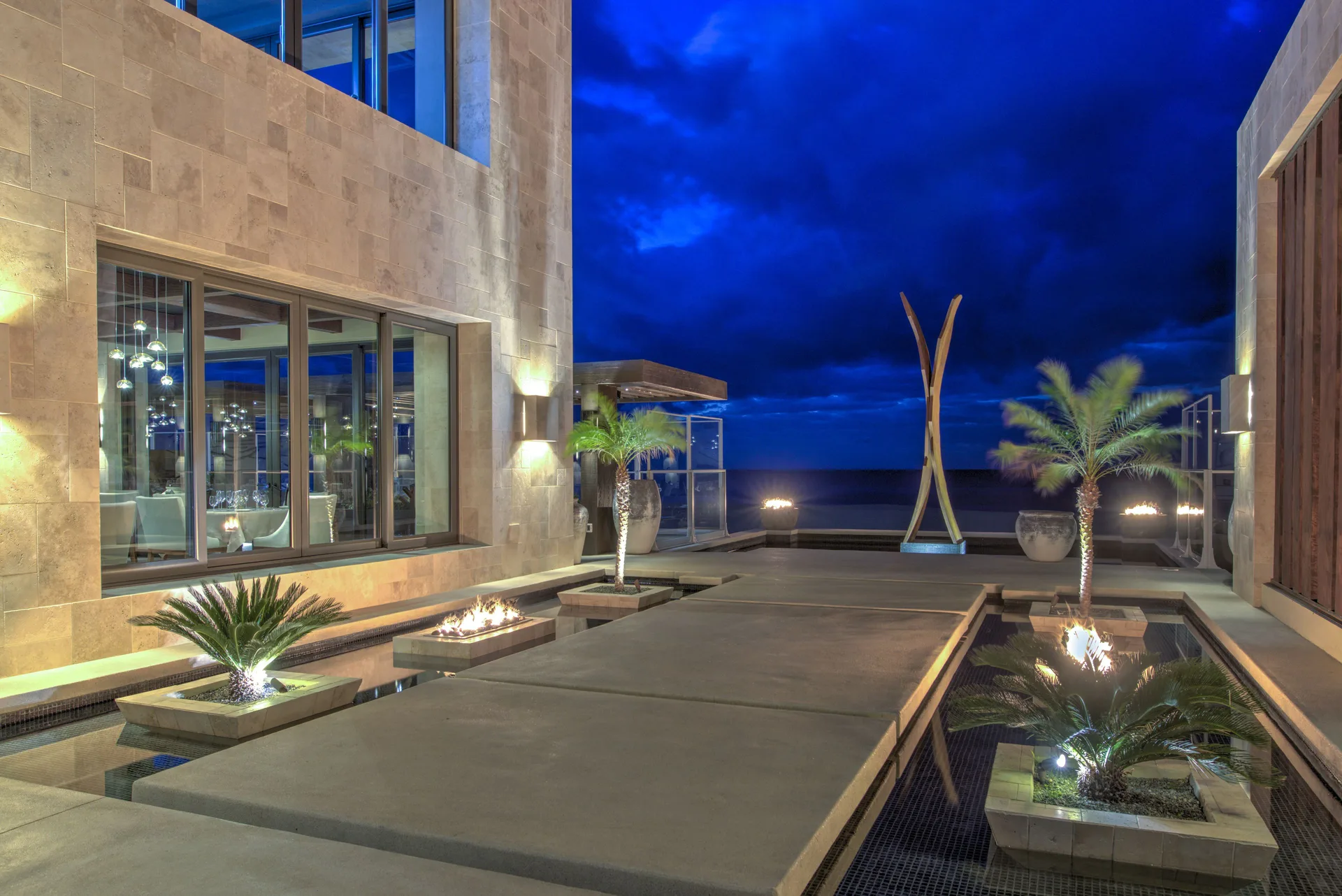Courtyard with fire features at night at Pueblo Bonito Pacifica Golf & Spa Resort.