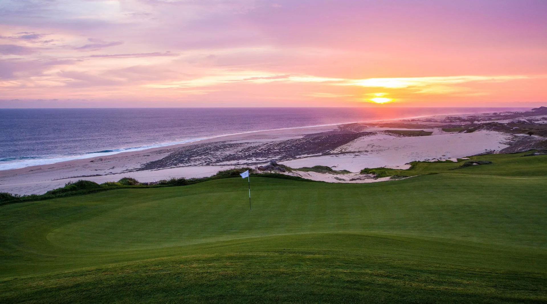Golf green and beach at sunset at Pueblo Bonito Pacifica Golf & Spa Resort.