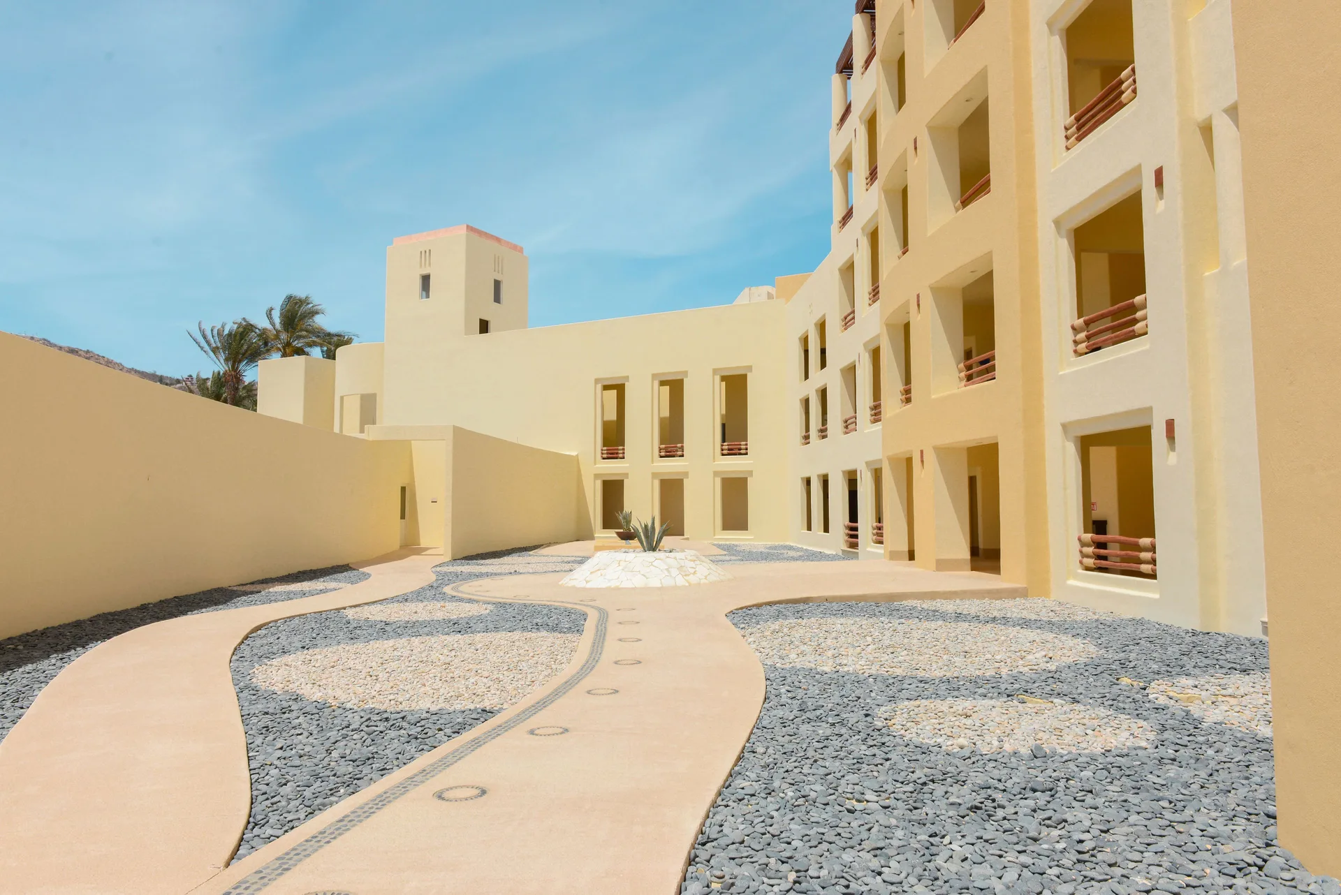 Guestroom balconies and curved courtyard paths at Pueblo Bonito Pacifica Golf & Spa Resort.