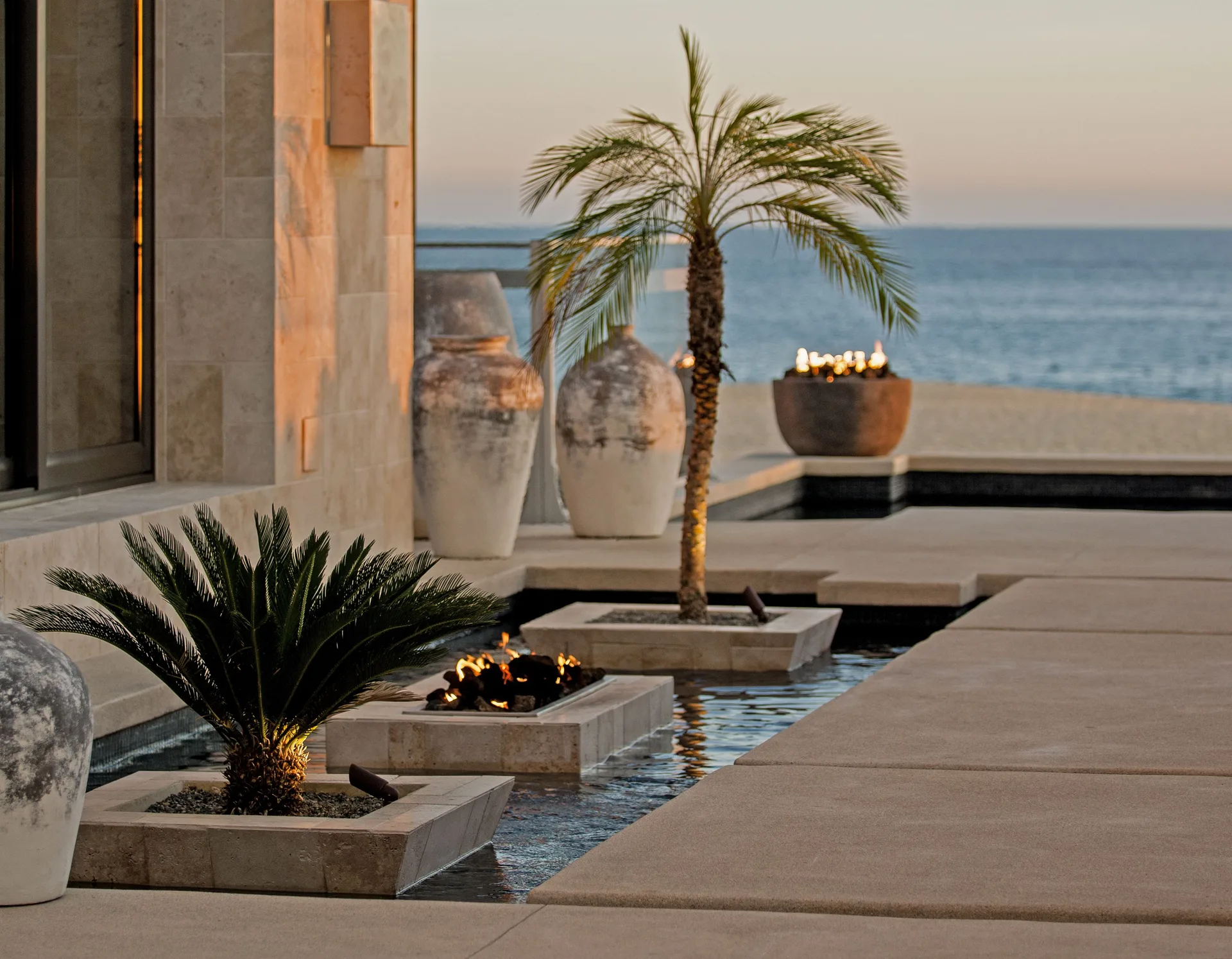 Reflecting pool with palms and ocean view at Pueblo Bonito Pacifica Golf & Spa Resort.