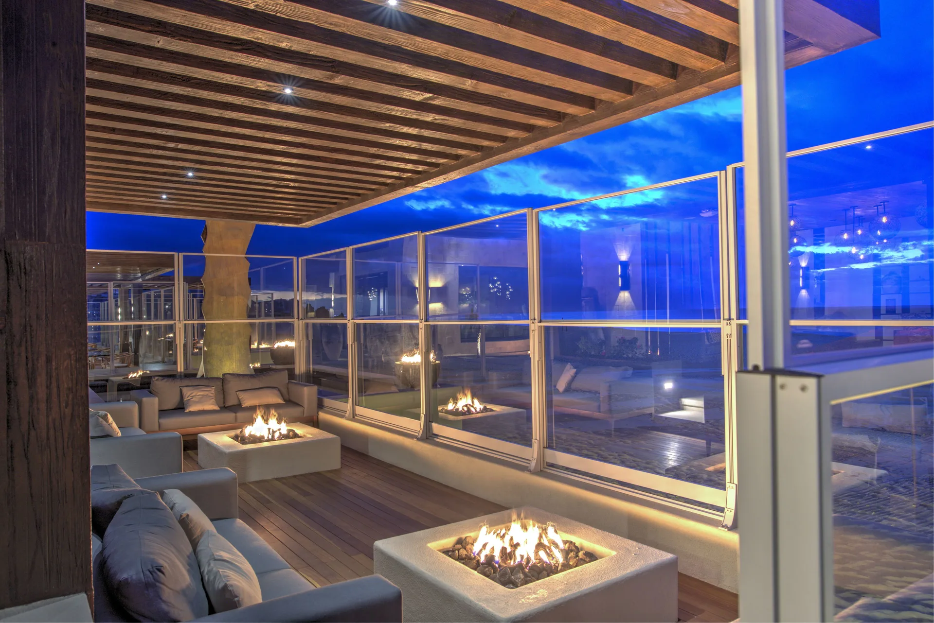 Terrace lounge with fire pits at dusk at Pueblo Bonito Pacifica Golf & Spa Resort.