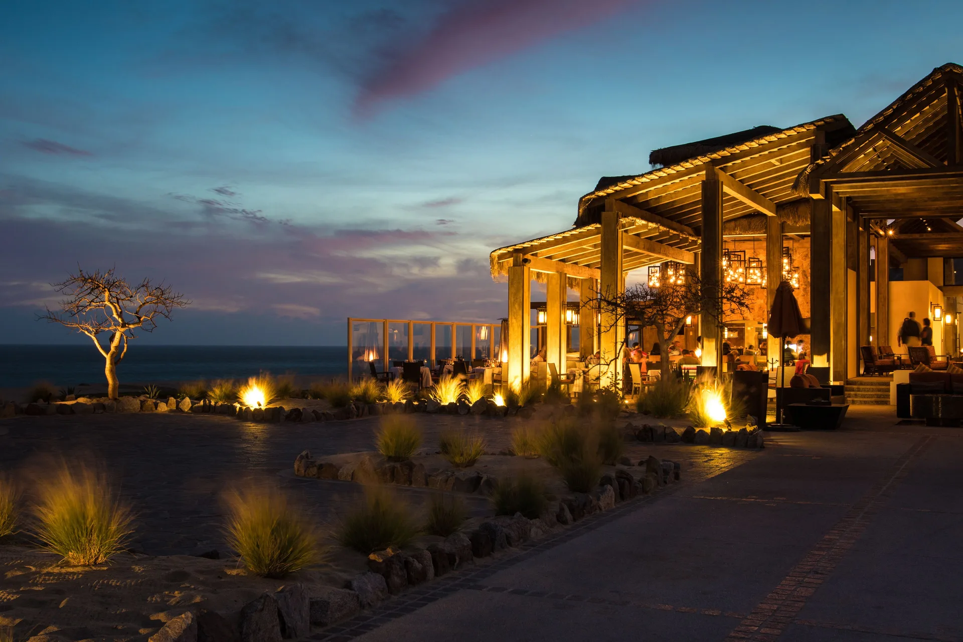 Open-air restaurant terrace at dusk at Pueblo Bonito Pacifica Golf & Spa Resort.