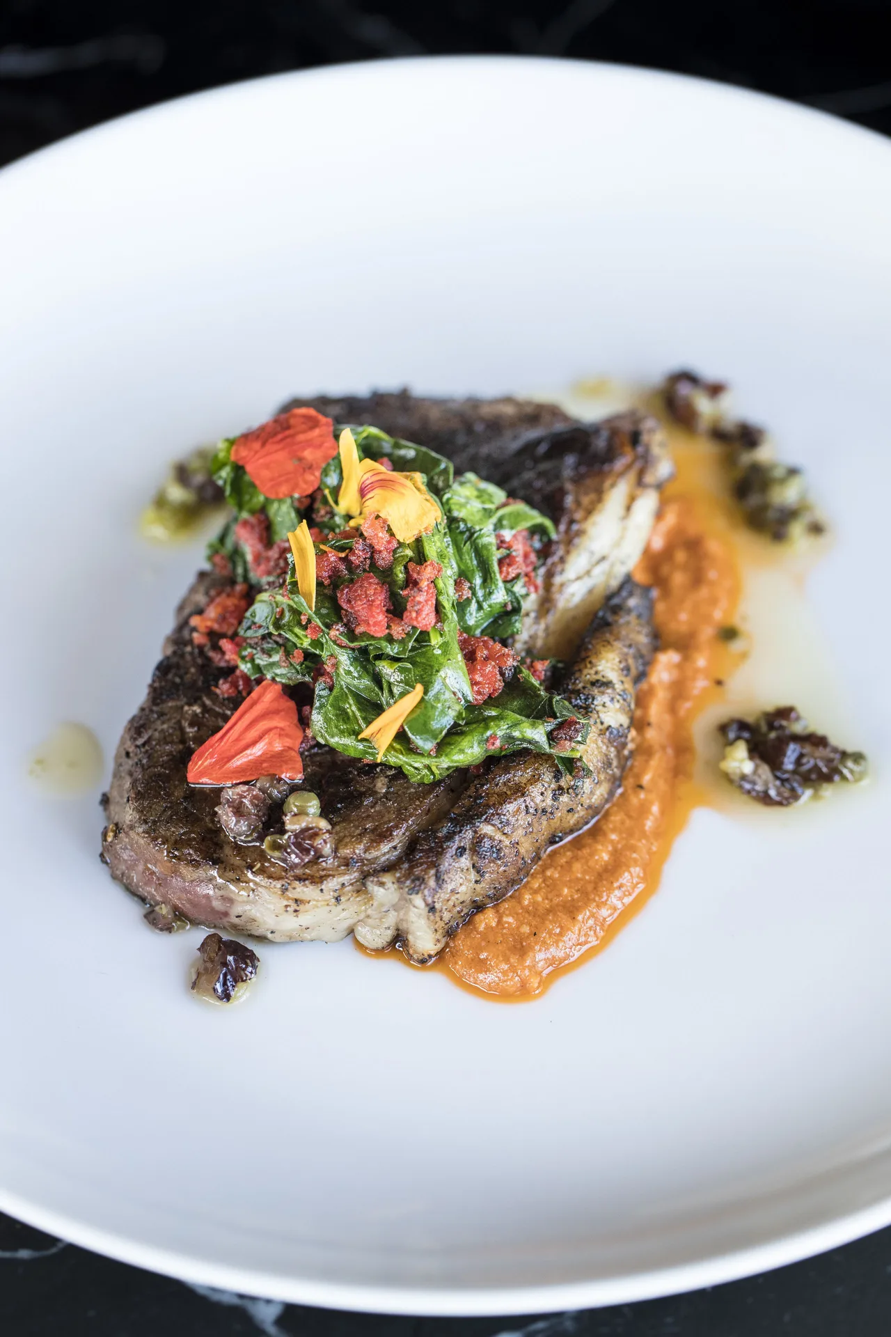 Plated steak with greens and sauce at Pueblo Bonito Pacifica Golf & Spa Resort.