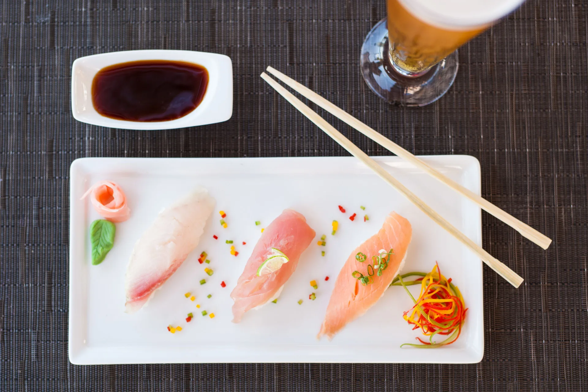 Sashimi plate with soy sauce, chopsticks, and beer at Pueblo Bonito Pacifica Golf & Spa Resort.