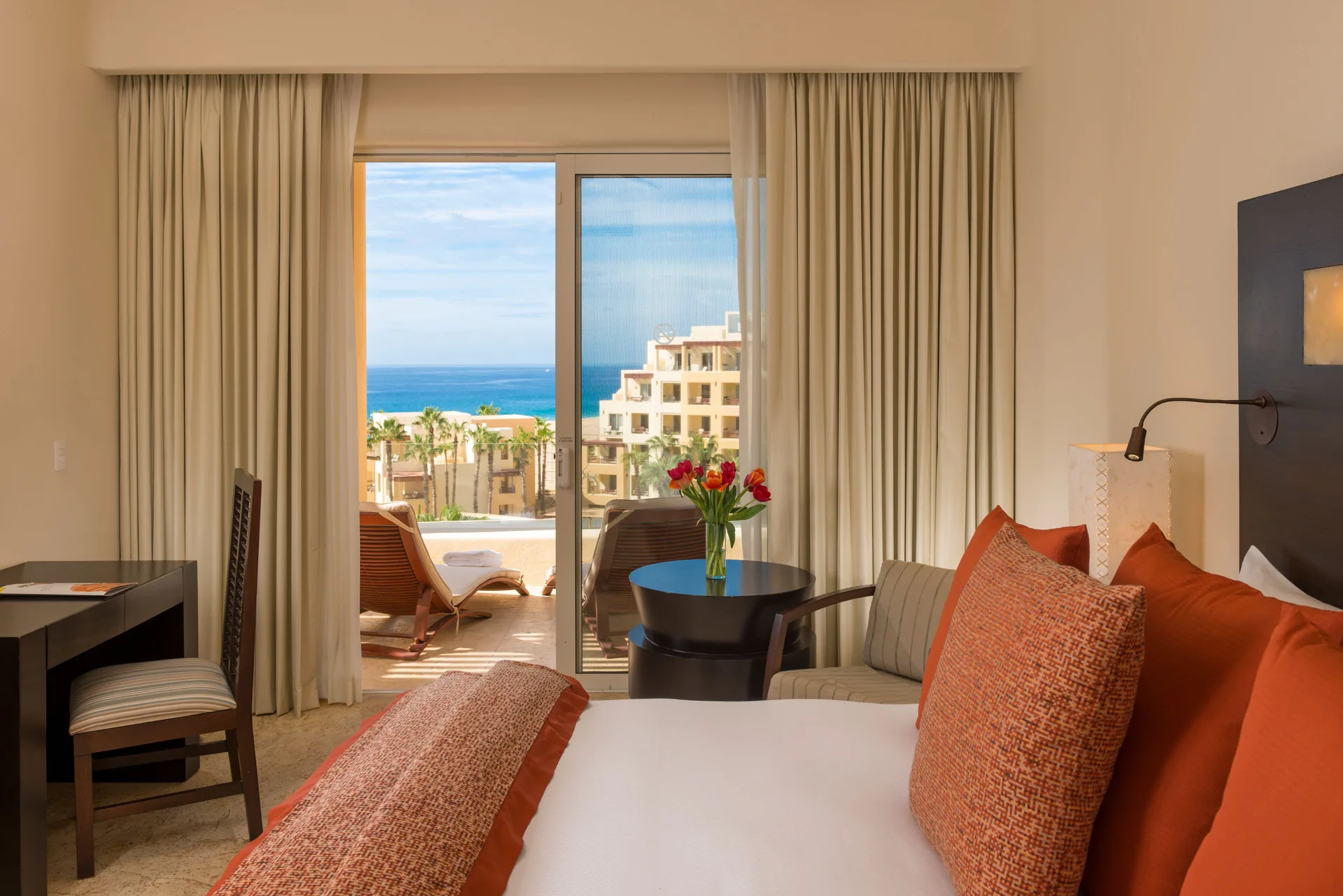 Deluxe Oceanview Room with king bed, sitting area, and balcony at Pueblo Bonito Pacifica Golf & Spa Resort.