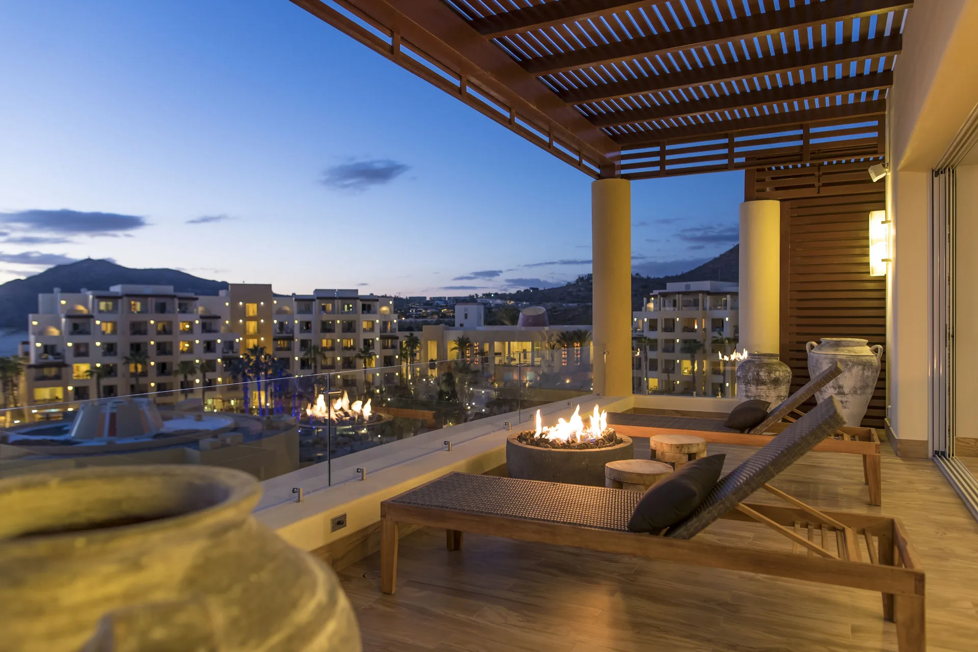 Towers Ocean View Suite terrace at Pueblo Bonito Pacifica Golf & Spa Resort with loungers and fire feature at dusk.