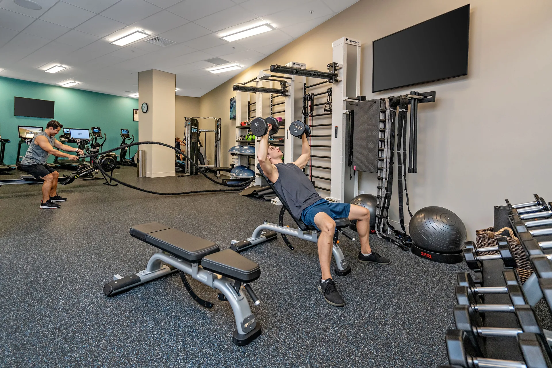 Guests use free weights and cardio equipment in the fitness center at Queen Kapiolani Hotel.