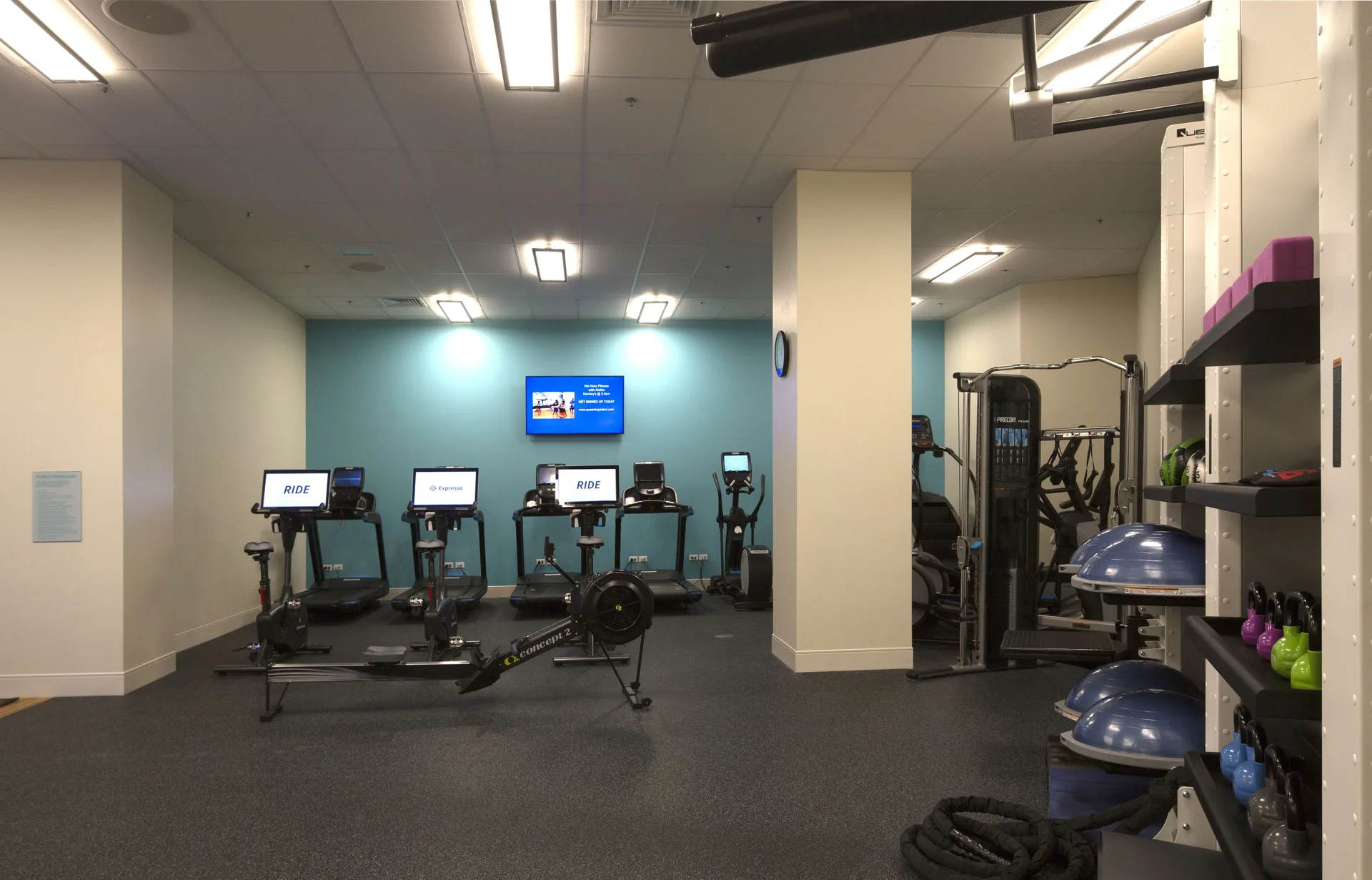 Cardio machines and strength equipment fill the fitness room at Queen Kapiolani Hotel.