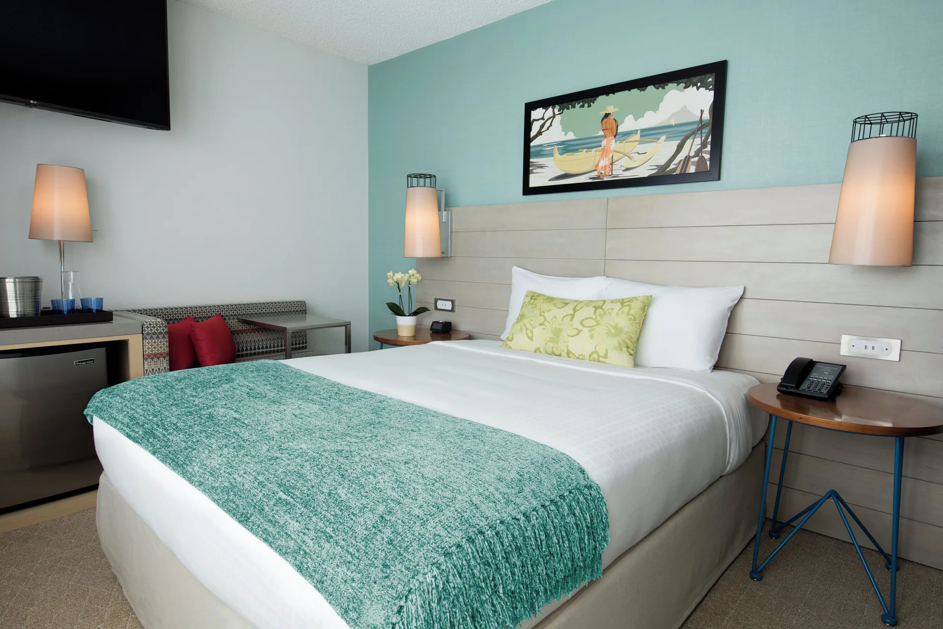 King guest room bed with bedside tables at Queen Kapiolani Hotel.