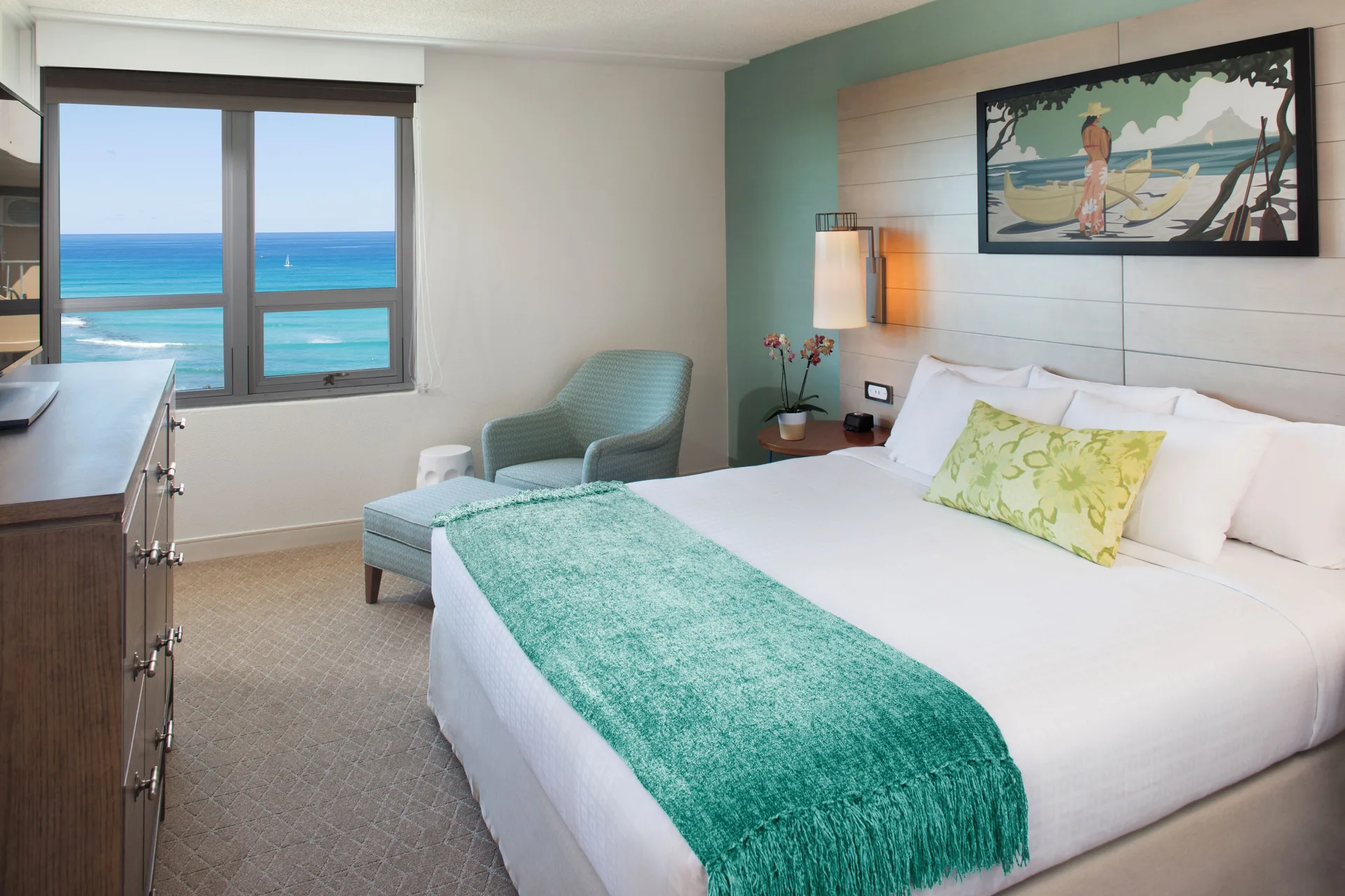 King guest room with ocean view window at Queen Kapiolani Hotel.