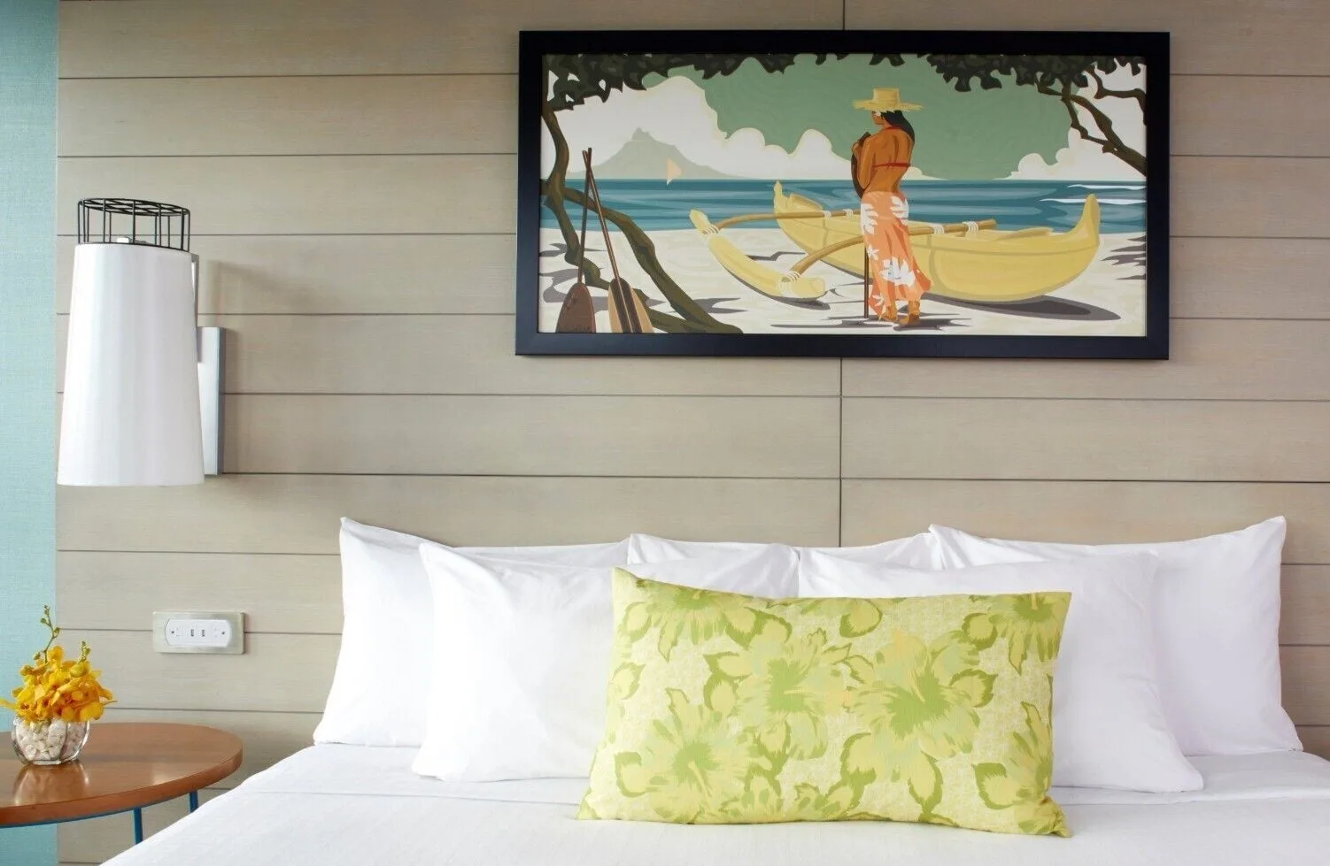 A close view of a king bed with tropical artwork at Queen Kapiolani Hotel.