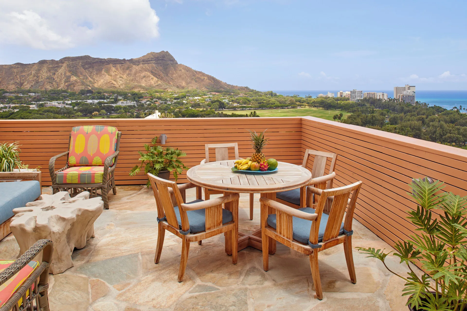 Private terrace with dining table and Diamond Head view at Queen Kapiolani Hotel.