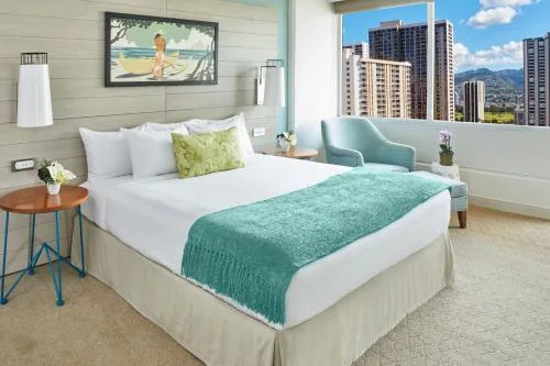 Penthouse One Bedroom City View Suite bedroom with turquoise accents at Queen Kapiolani Hotel.