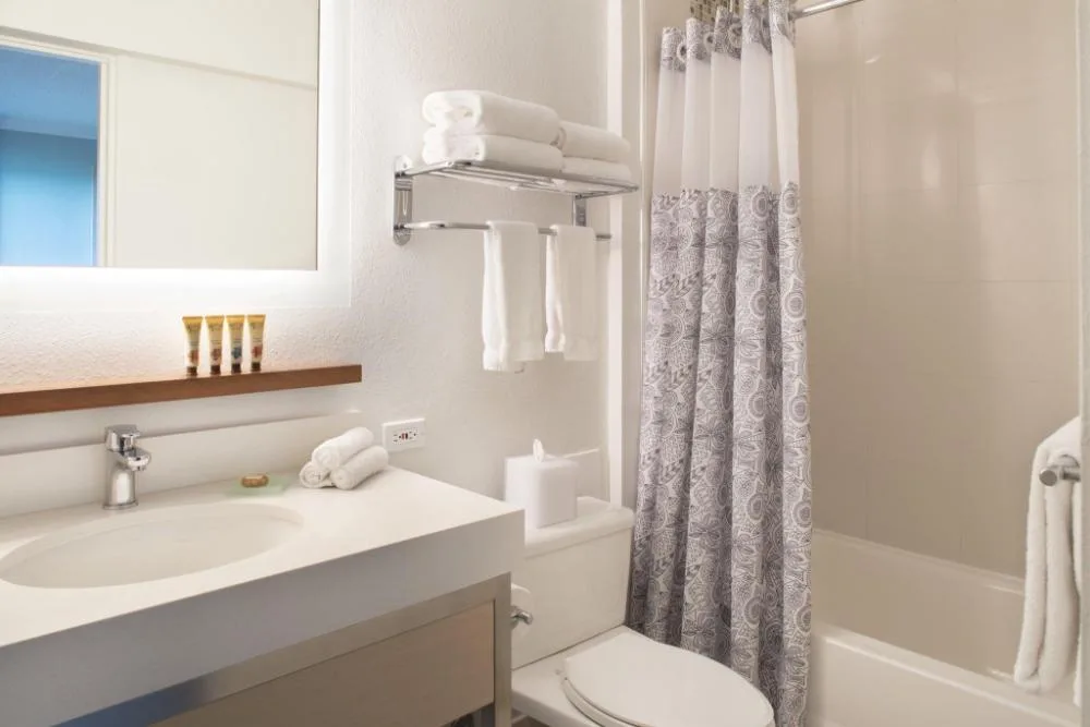 Penthouse One Bedroom Ocean View Suite bathroom with vanity and tub at Queen Kapiolani Hotel.