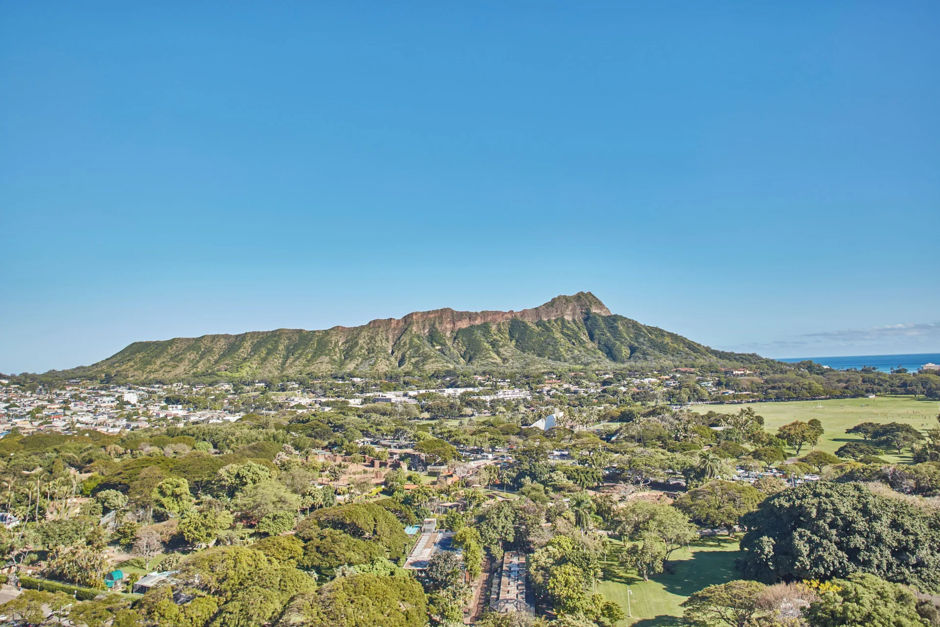 Diamond Head and park view from Queen Kapiolani Hotel under a clear blue sky.