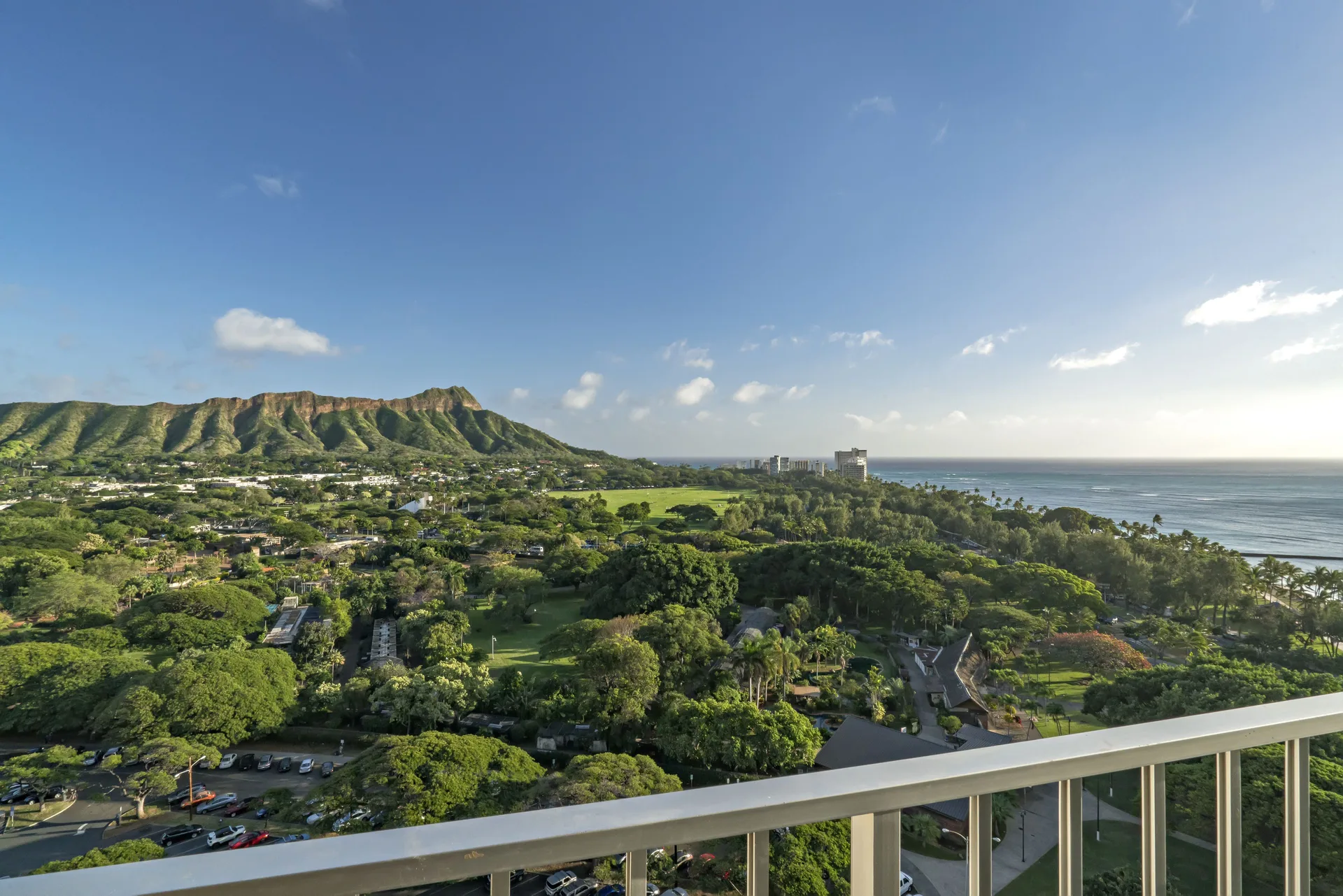 Grand Le'āhi Junior Suite at Queen Kapiolani Hotel with balcony, ocean views, and Diamond Head backdrop in Waikiki, Honolulu.
