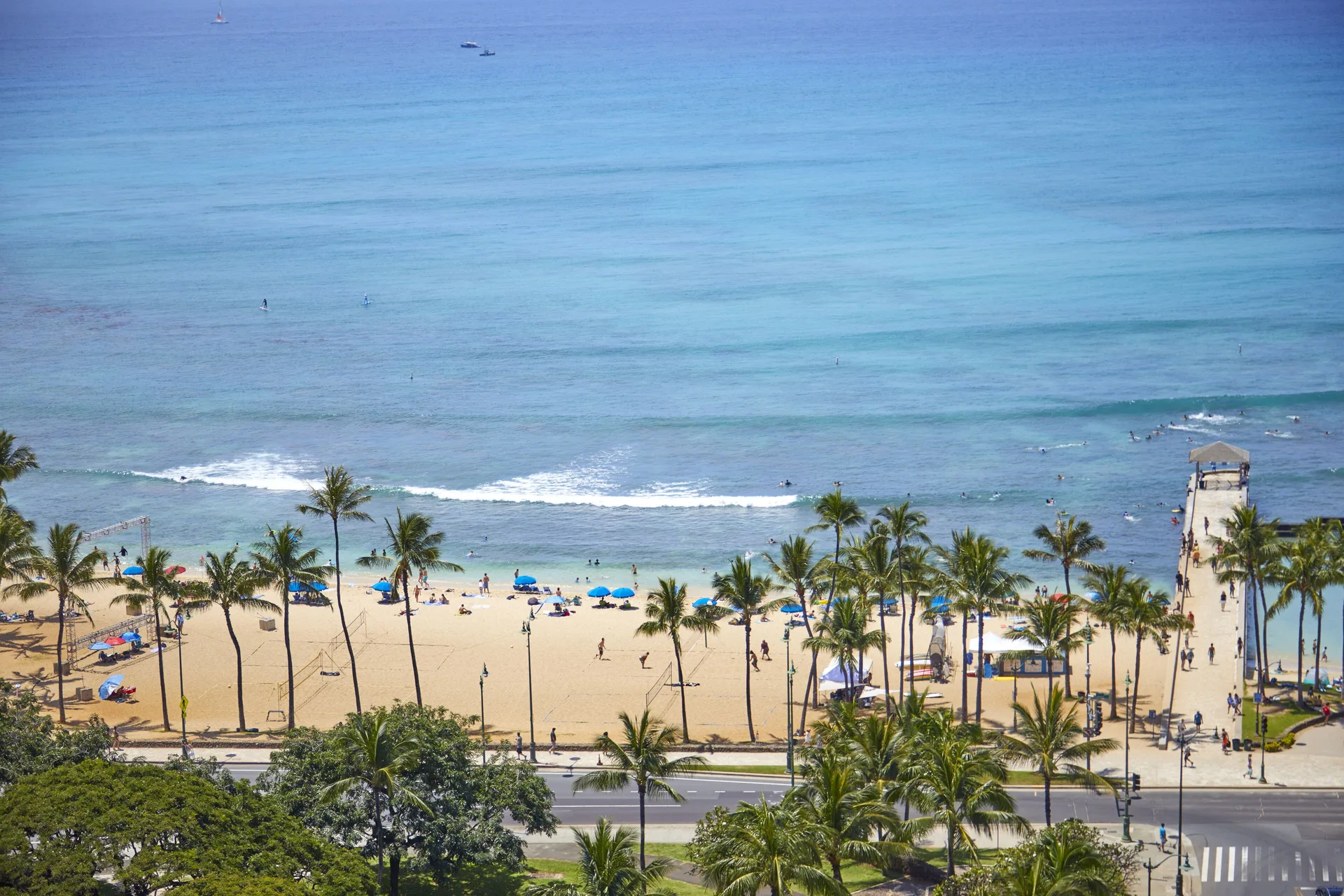 Ocean view from a studio room at Queen Kapiolani Hotel overlooking Waikiki Beach and palm trees.
