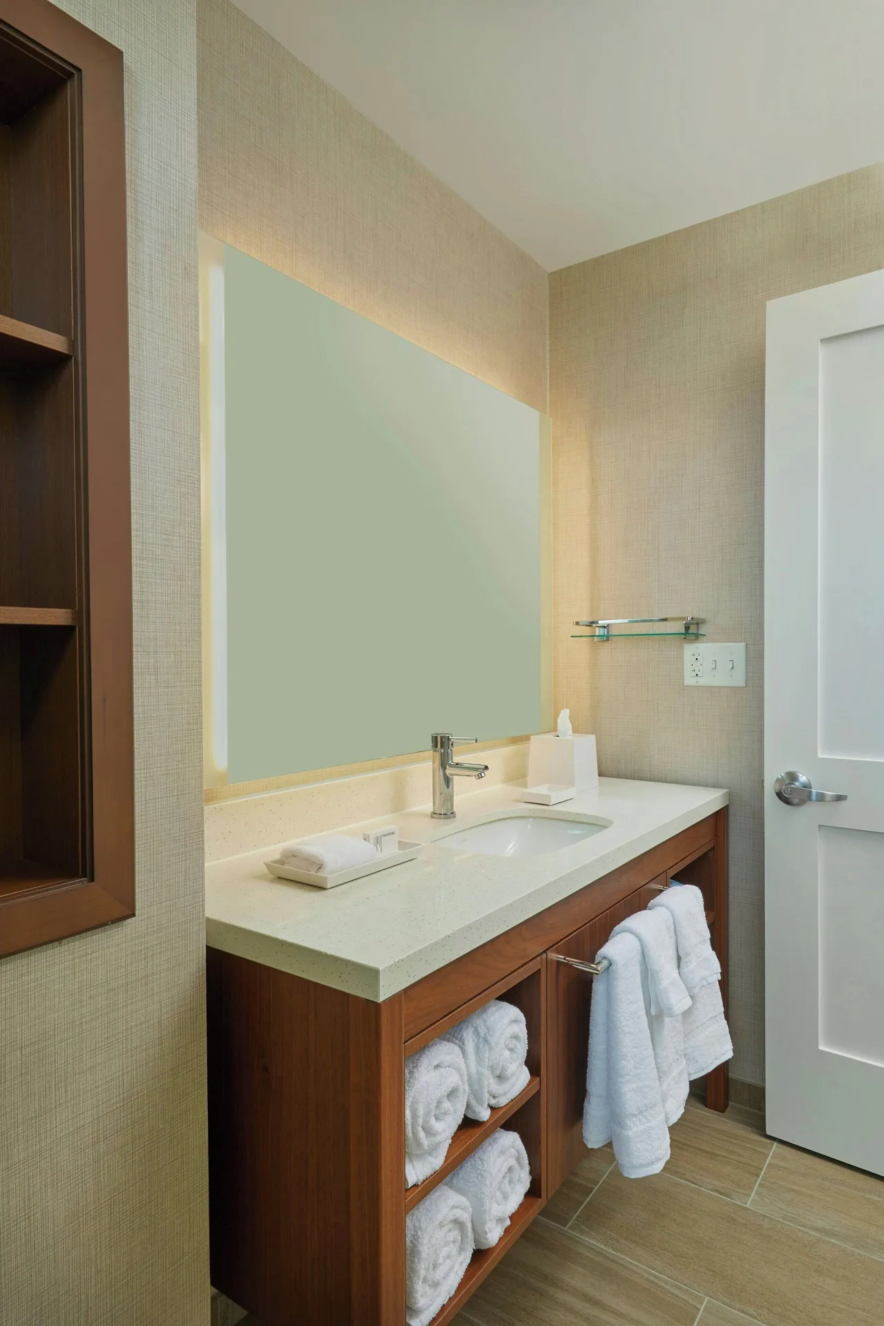 Bathroom vanity with towels and illuminated mirror at Residence Inn Oahu Kapolei.