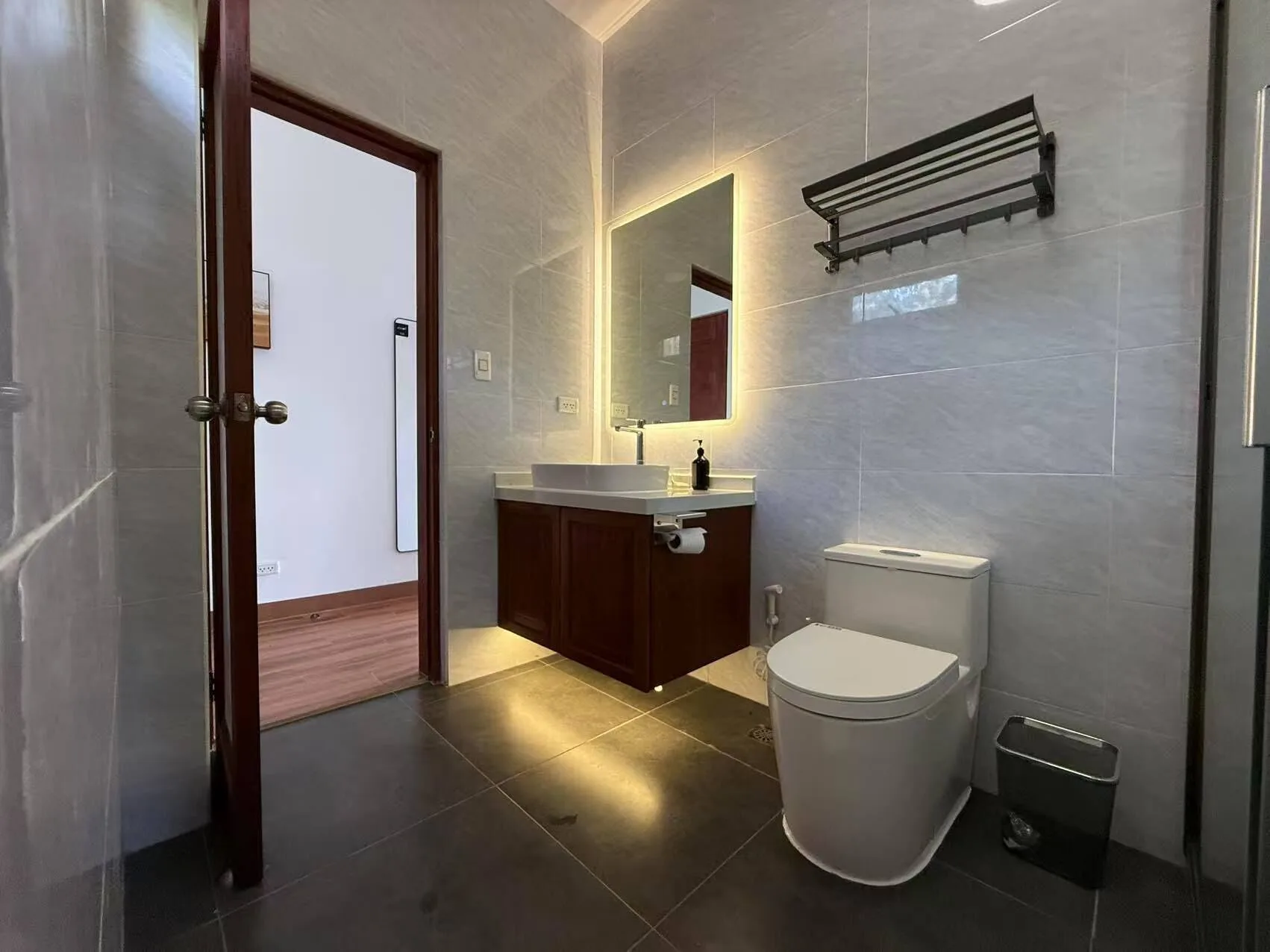 Luxury Room Beach View bathroom with vanity, toilet, and tiled walls at Resort Deja Vu.