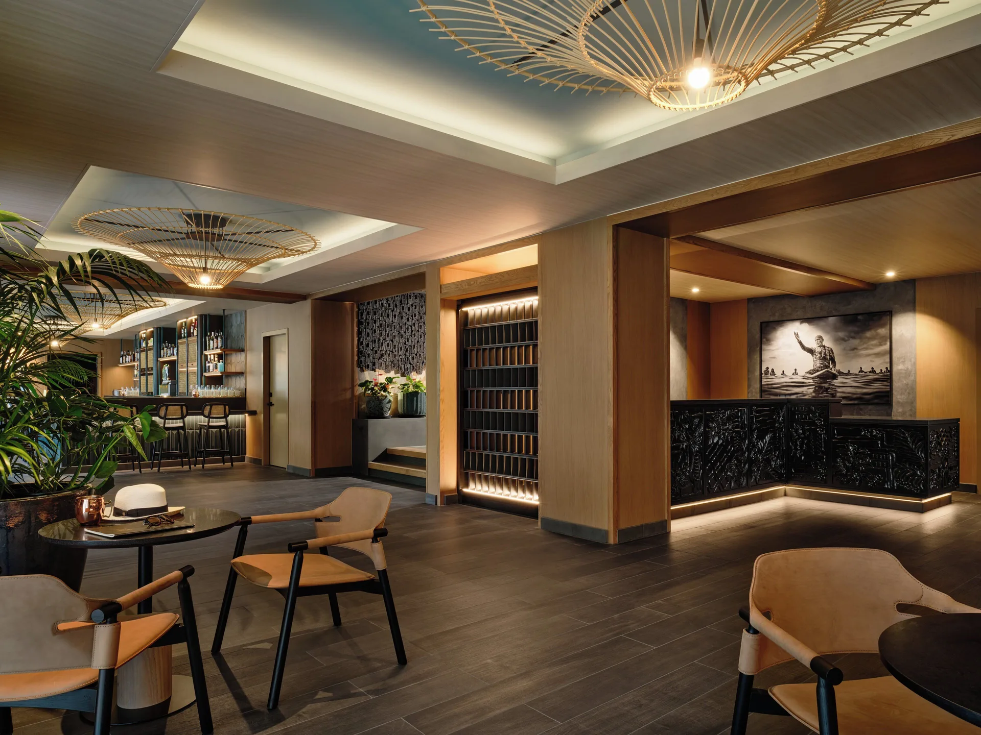 Lobby lounge and bar area with woven ceiling lights at Romer House Waikiki.