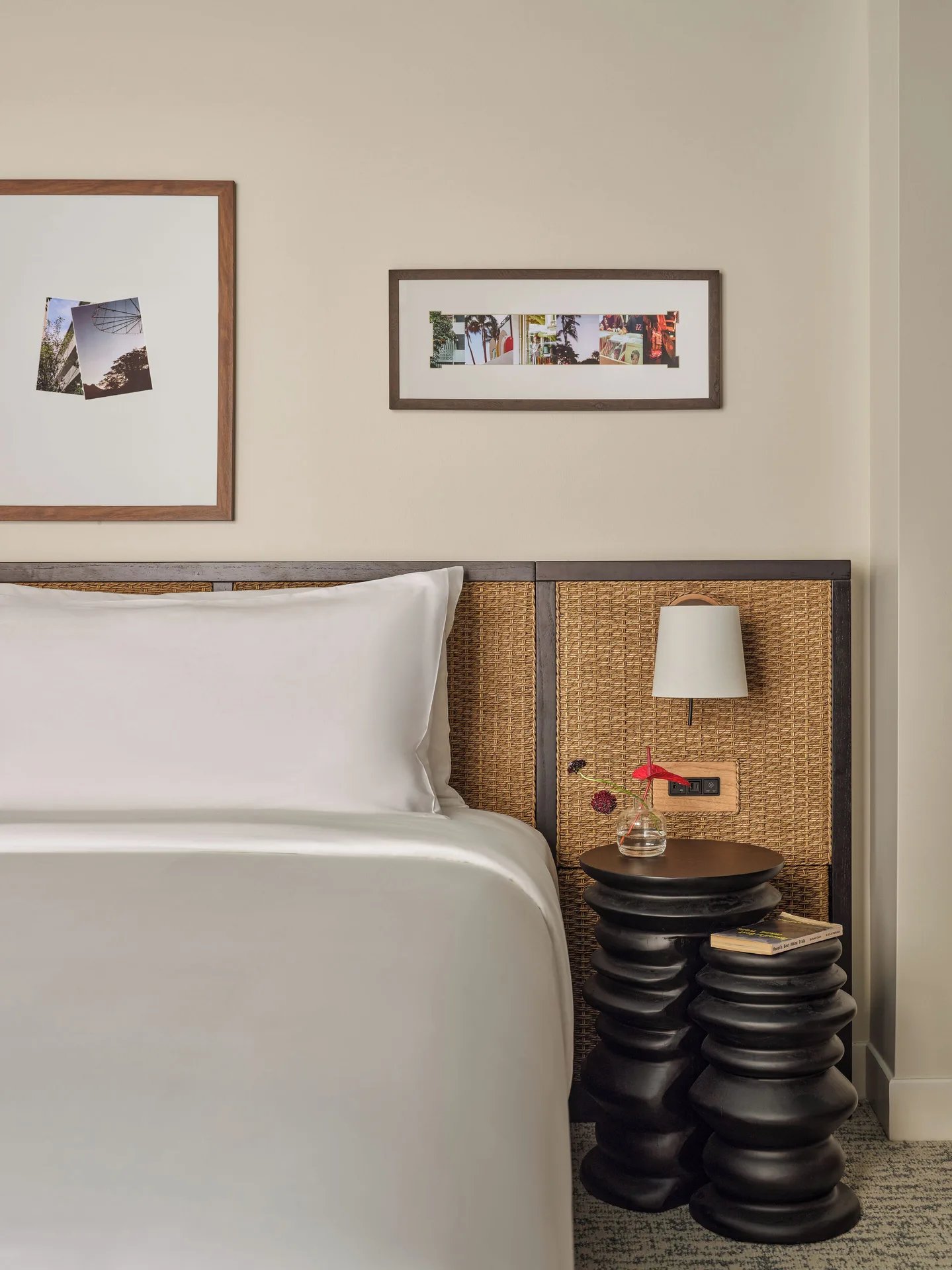 Standard room bed and bedside tables at Romer House Waikiki with framed wall art.