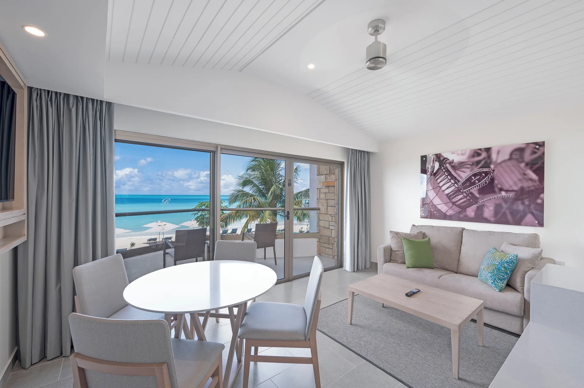 Ocean-view living area with sofa and dining table at Royalton CHIC Antigua.