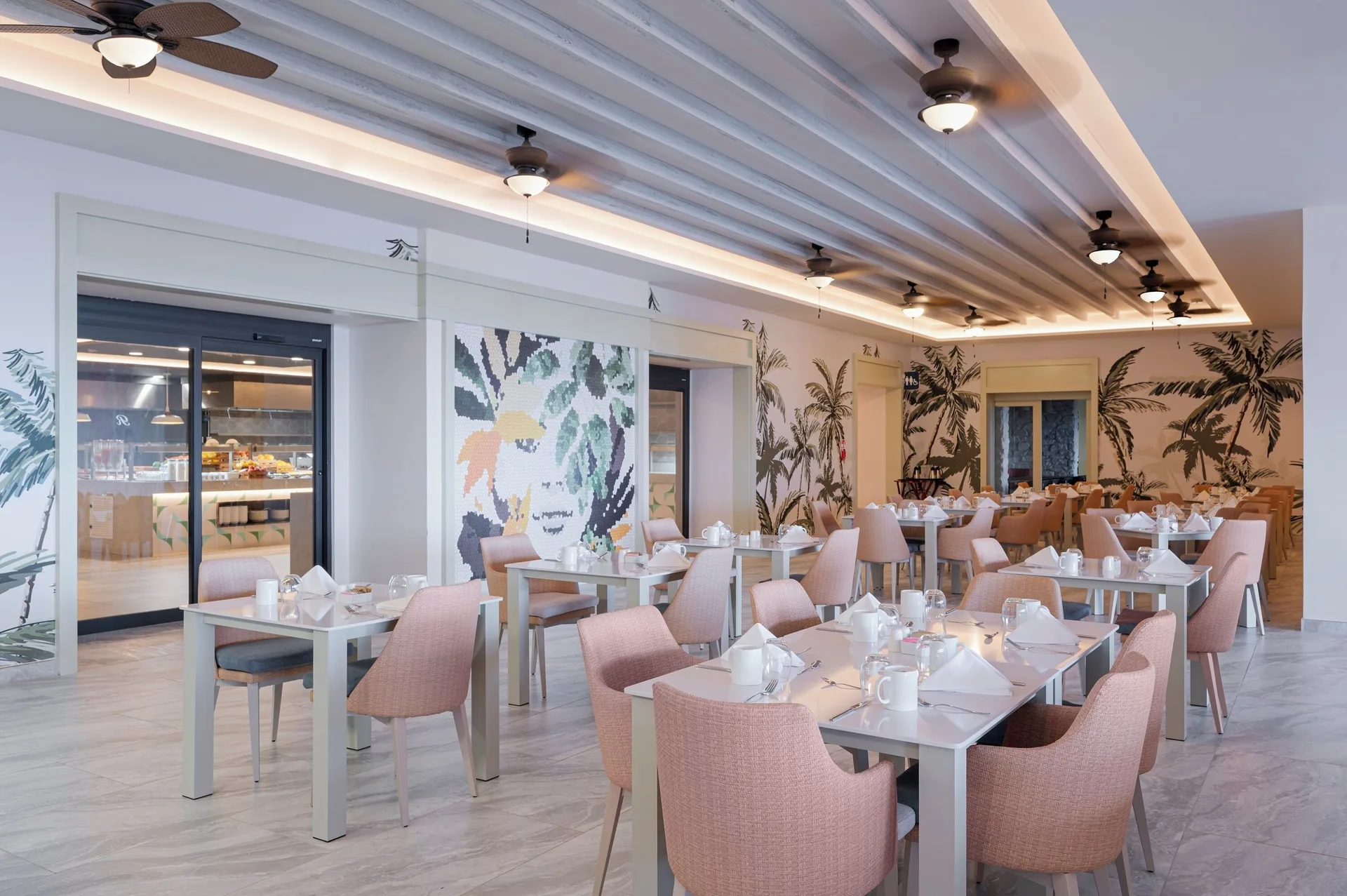 Bright buffet-style dining room with tropical wall art at Royalton CHIC Antigua.