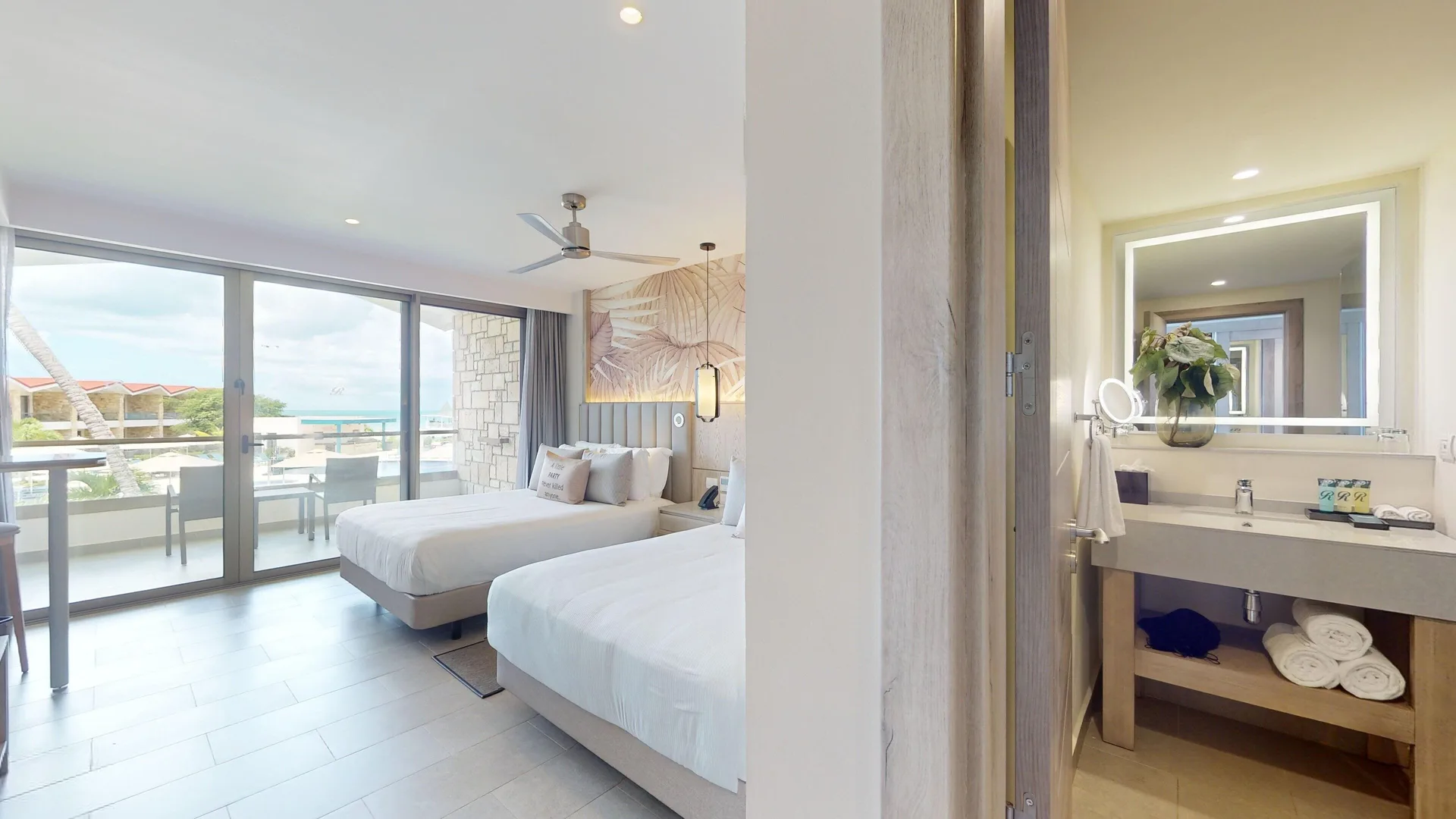 Guest room and vanity in a Luxury Garden View Room Diamond Club at Royalton CHIC Antigua.