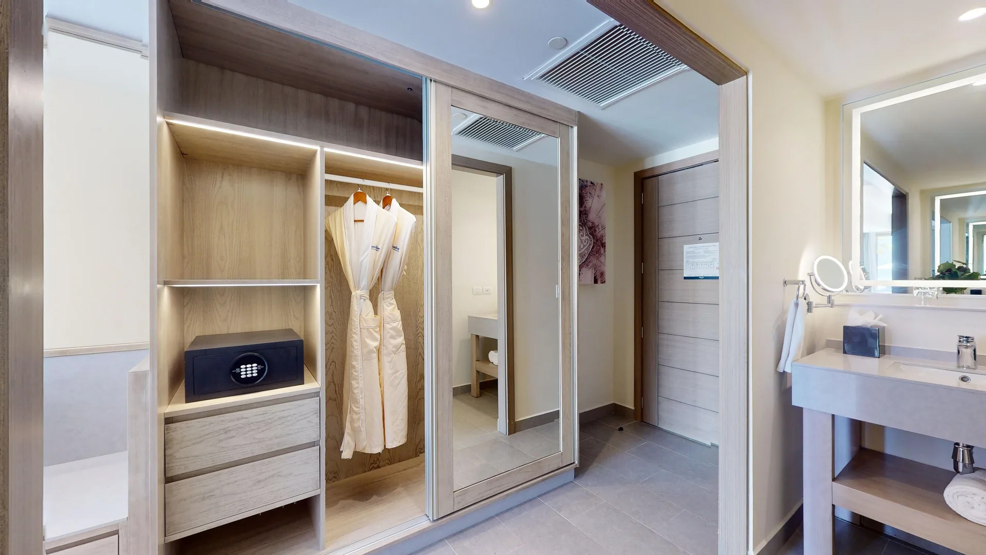 Suite closet with robes, safe, and vanity in a guest room at Royalton CHIC Antigua.