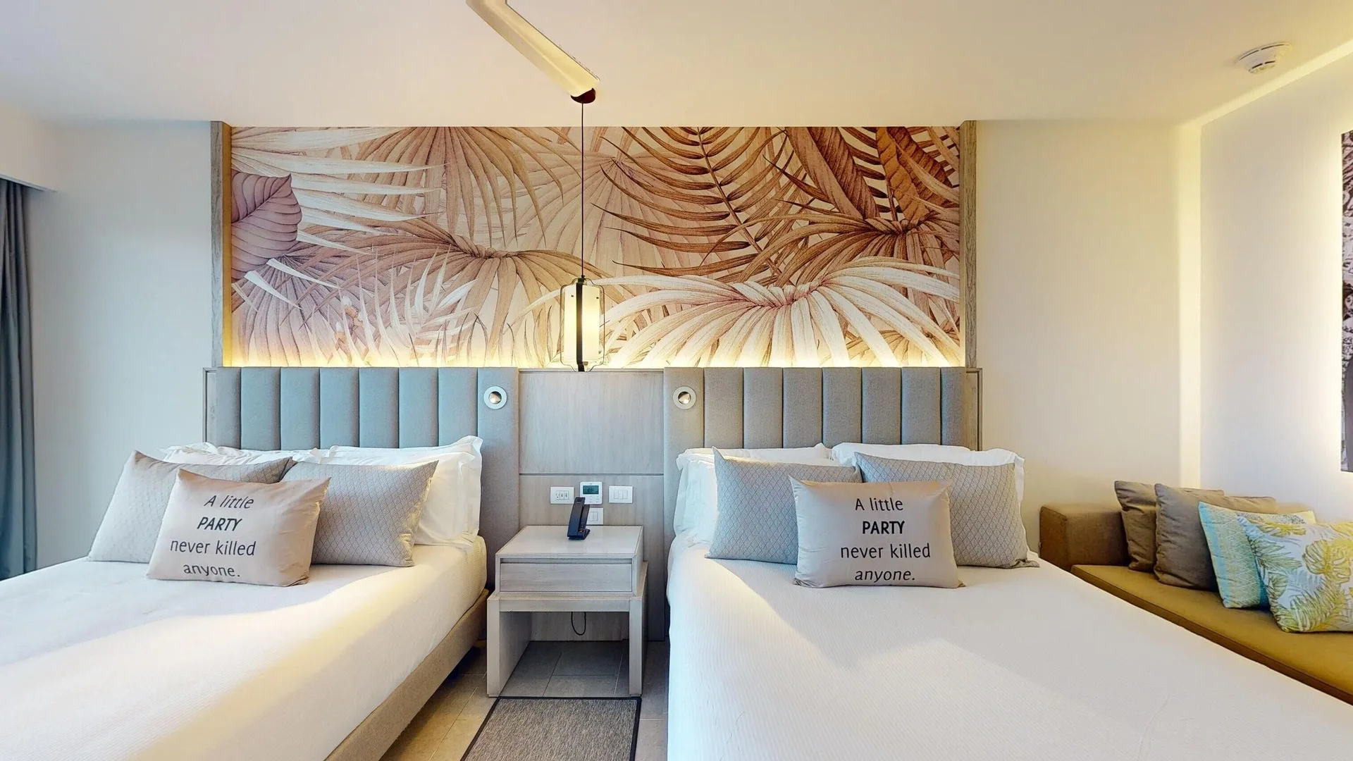 Two beds in a beachfront swim-out junior suite at Royalton CHIC Antigua beneath a tropical mural.