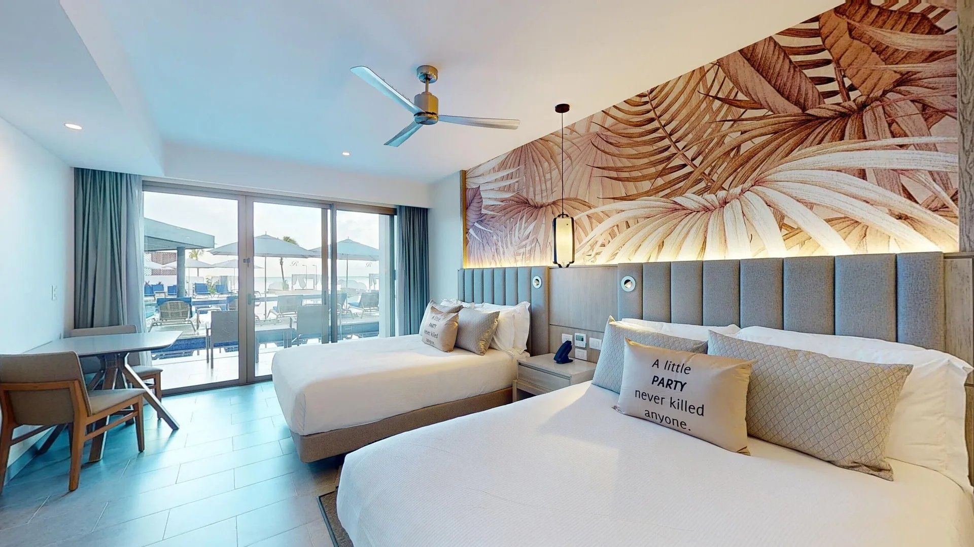 Two-bed beachfront swim-out junior suite at Royalton CHIC Antigua with terrace doors and loungers outside.