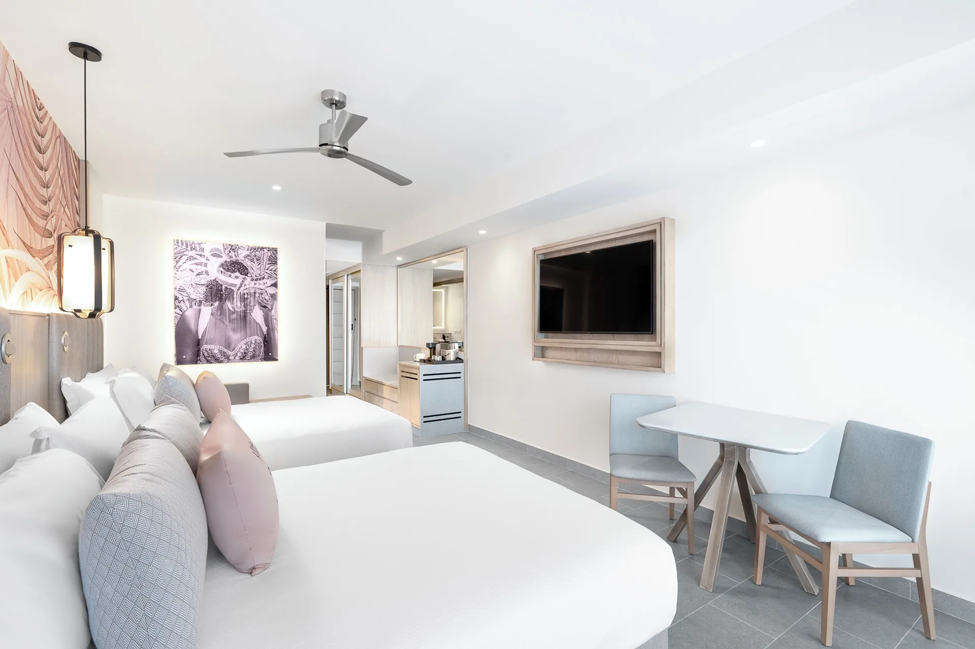 Two-bed beachfront swim-out junior suite guest room at Royalton CHIC Antigua with wall-mounted TV.