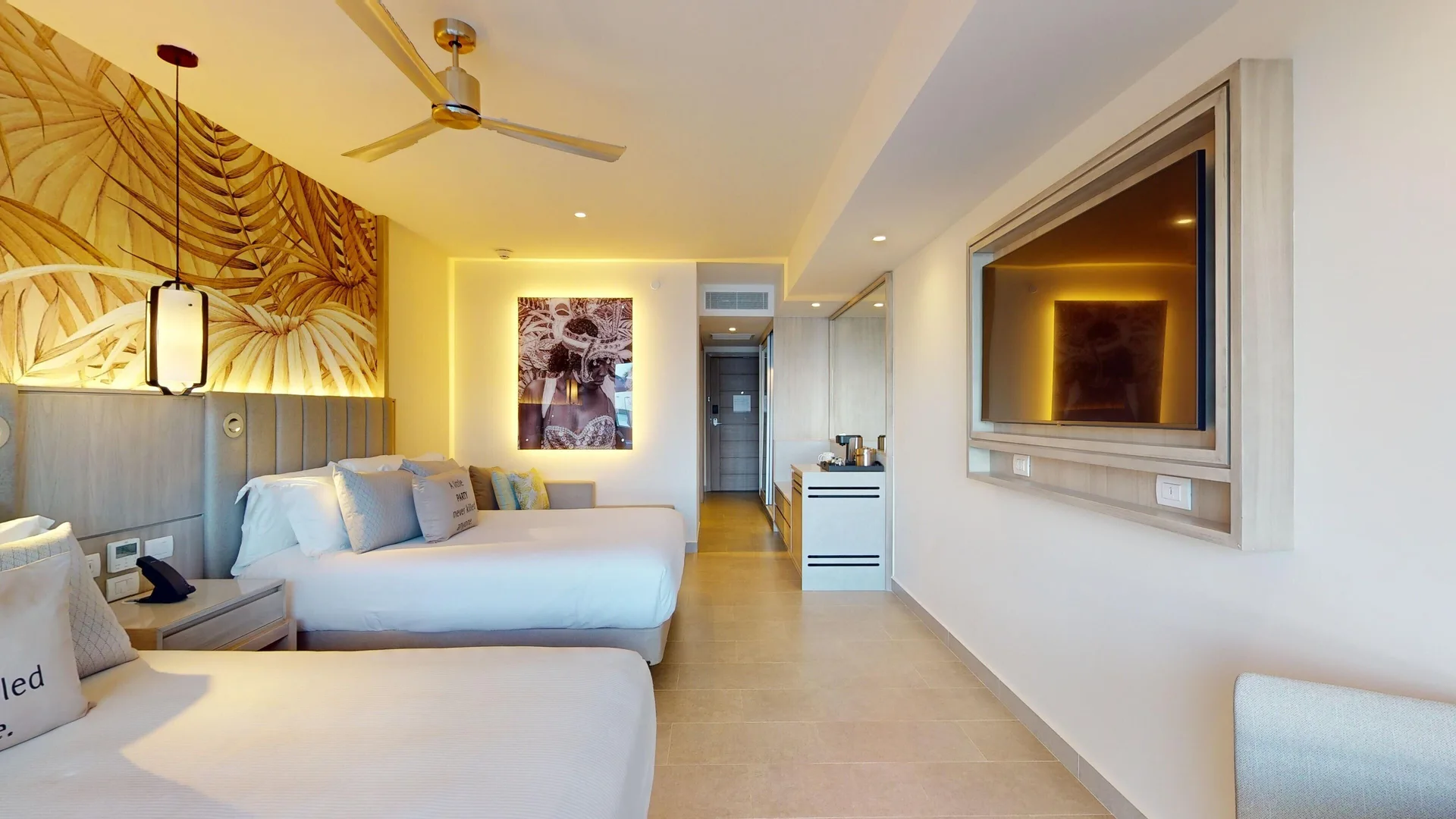 Two-bed beachfront swim-out junior suite at Royalton CHIC Antigua with TV wall and ceiling fan.